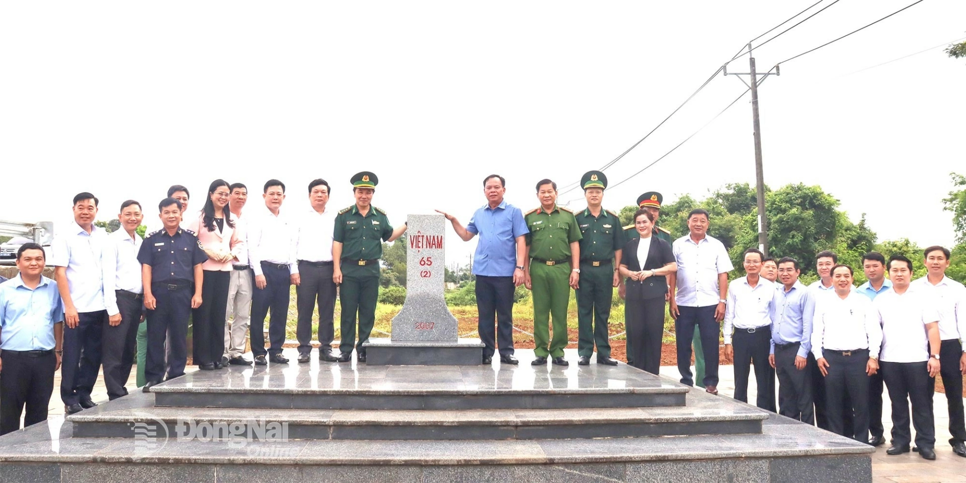 Vo Tan Duc, Deputy Secretary of the Provincial Party Committee and Chairman of the Dong Nai Provincial Peoples Committee (right of the border marker), poses for a commemorative photo with the delegation at the Hoang Dieu Border Guard Station marker during an inspection and survey along the province’s border. Photo: Nguyet Ha