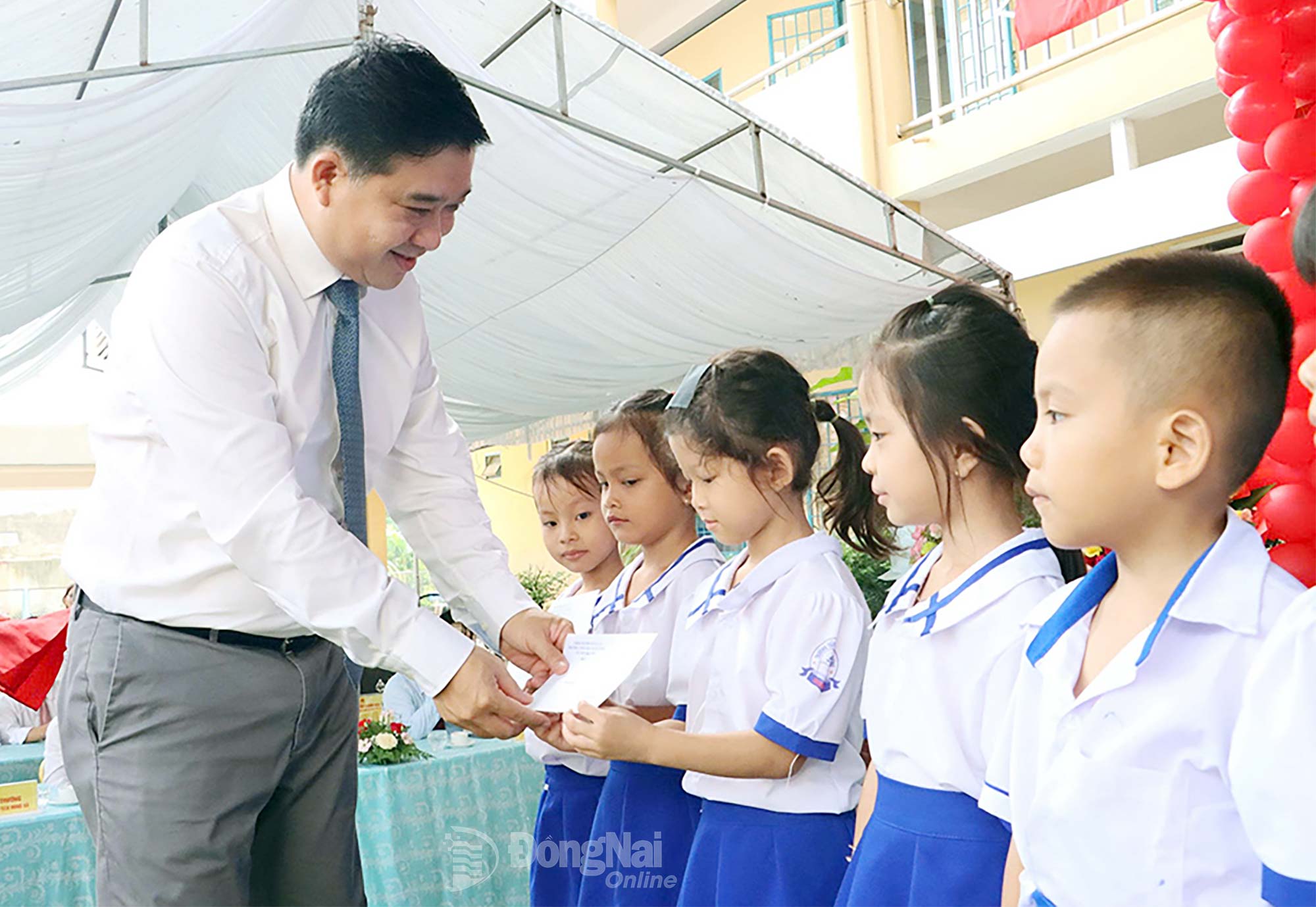 Member of the Provincial Party Committee and Vice Chairman of Dong Nai People’s Committee Ho Van Ha presents scholarships to students at Xuan Hung Primary School. Photo: Van Doan