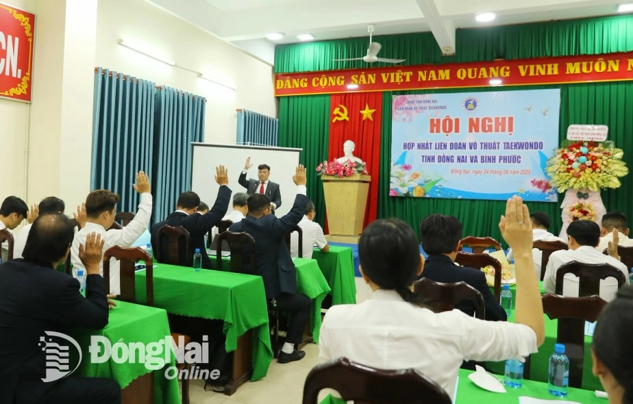 Delegates attending the conference vote to approve the project to merge the Taekwondo Federations of Dong Nai and Binh Phuoc provinces. Photo: Huy Anh