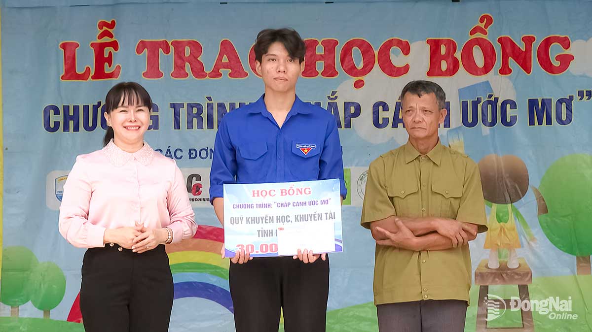 Đại diện lãnh đạo xã Lộc Ninh động viên và trao học bổng cho em Biên. Ảnh: Phú Quý

