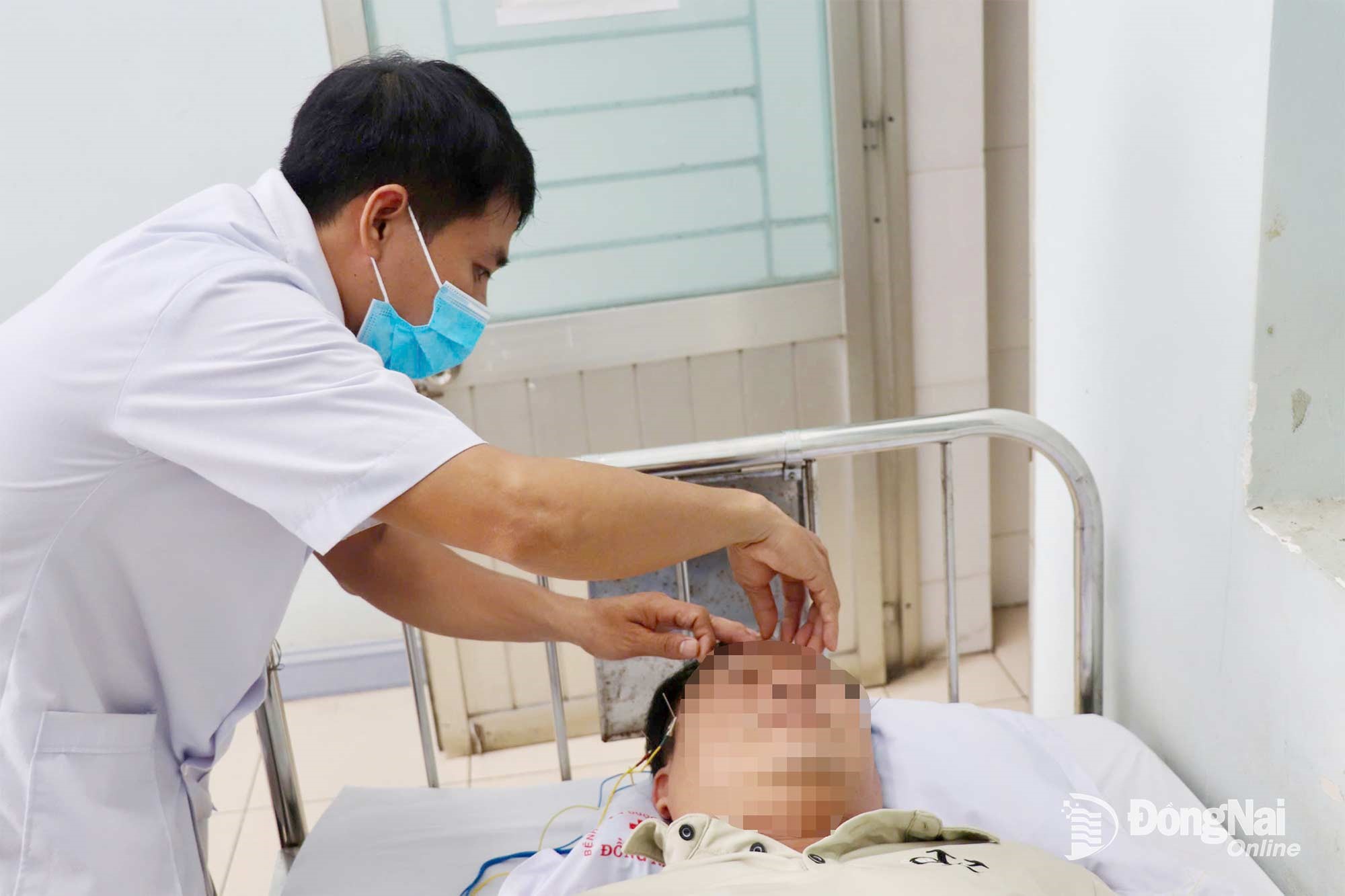 A patient suffering from neck and shoulder pain leading to headaches receives electroacupuncture treatment at Dong Nai Traditional Medicine Hospital. Photo: Hai Yen