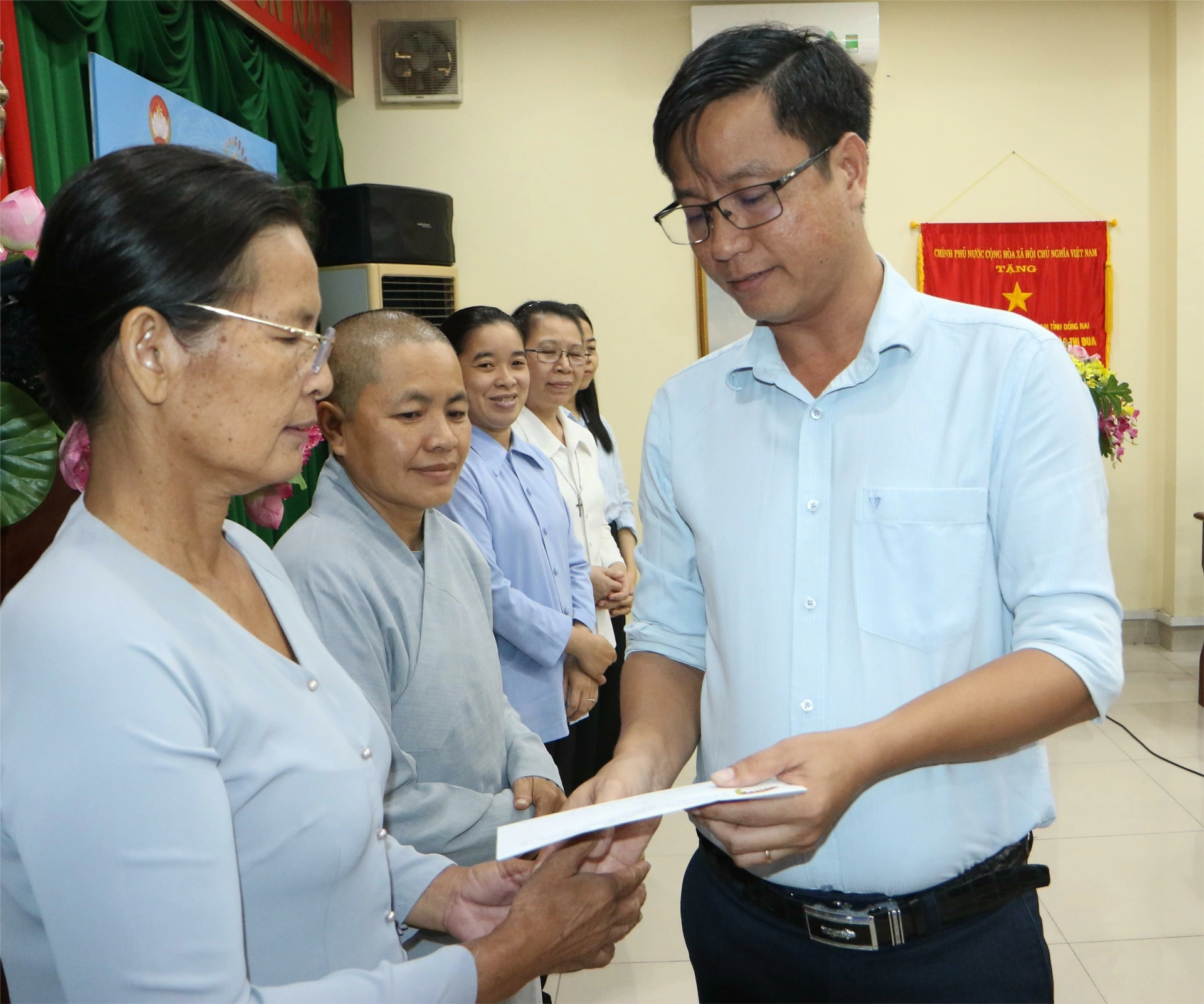 Phó Ban Quản lý dự án Liên hiệp Hợp tác xã dịch vụ nông nghiệp tổng hợp Đồng Nai Nguyễn Ngọc Tính trao quà đến các cơ sở bảo trợ xã hội trong tỉnh. Ảnh: Văn Truyên