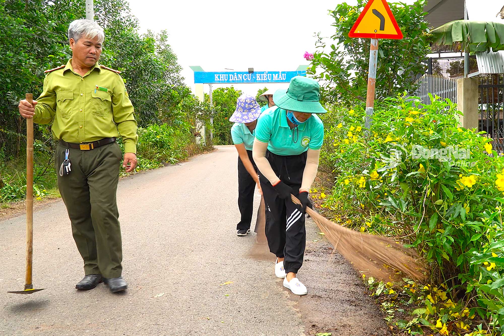 Thành viên Câu lạc bộ xanh Hồng Hoàng dọn dẹp vệ sinh làm đẹp tuyến đường hoa tại ấp 4, xã Phú Lý, tỉnh Đồng Nai. Ảnh: An Nhơn