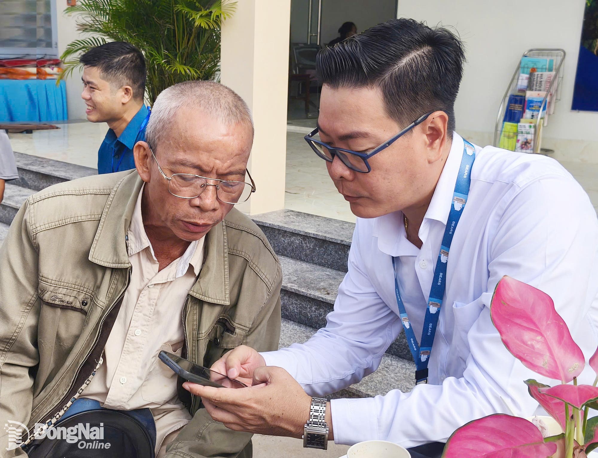 Chủ tịch UBND xã Võ Văn Trung trực tiếp hướng dẫn người dân cài đặt ứng dụng và thao tác trên điện thoại thông minh. Ảnh: Hà Nội