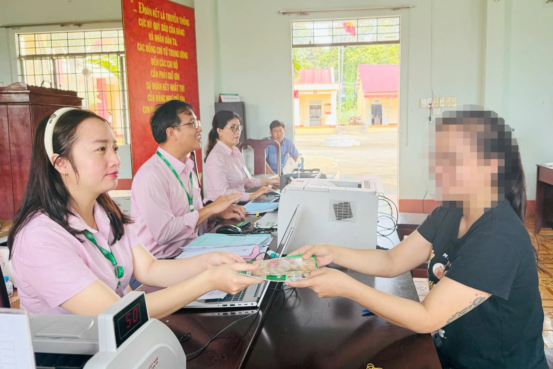 An employee of the VBSP - Dong Nai City Branch disburses policy credit funds to a family with a child attending school in Thanh Bien Hamlet, Loc Thanh Commune. 

