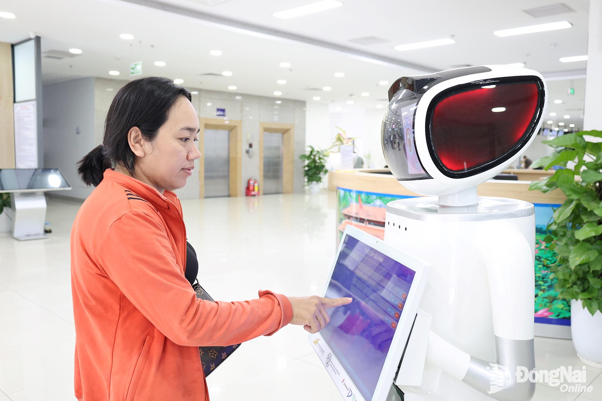 Residents interact with a robot to complete administrative procedures at the citys Public Administration Service Center. Photo: Ho Thao

