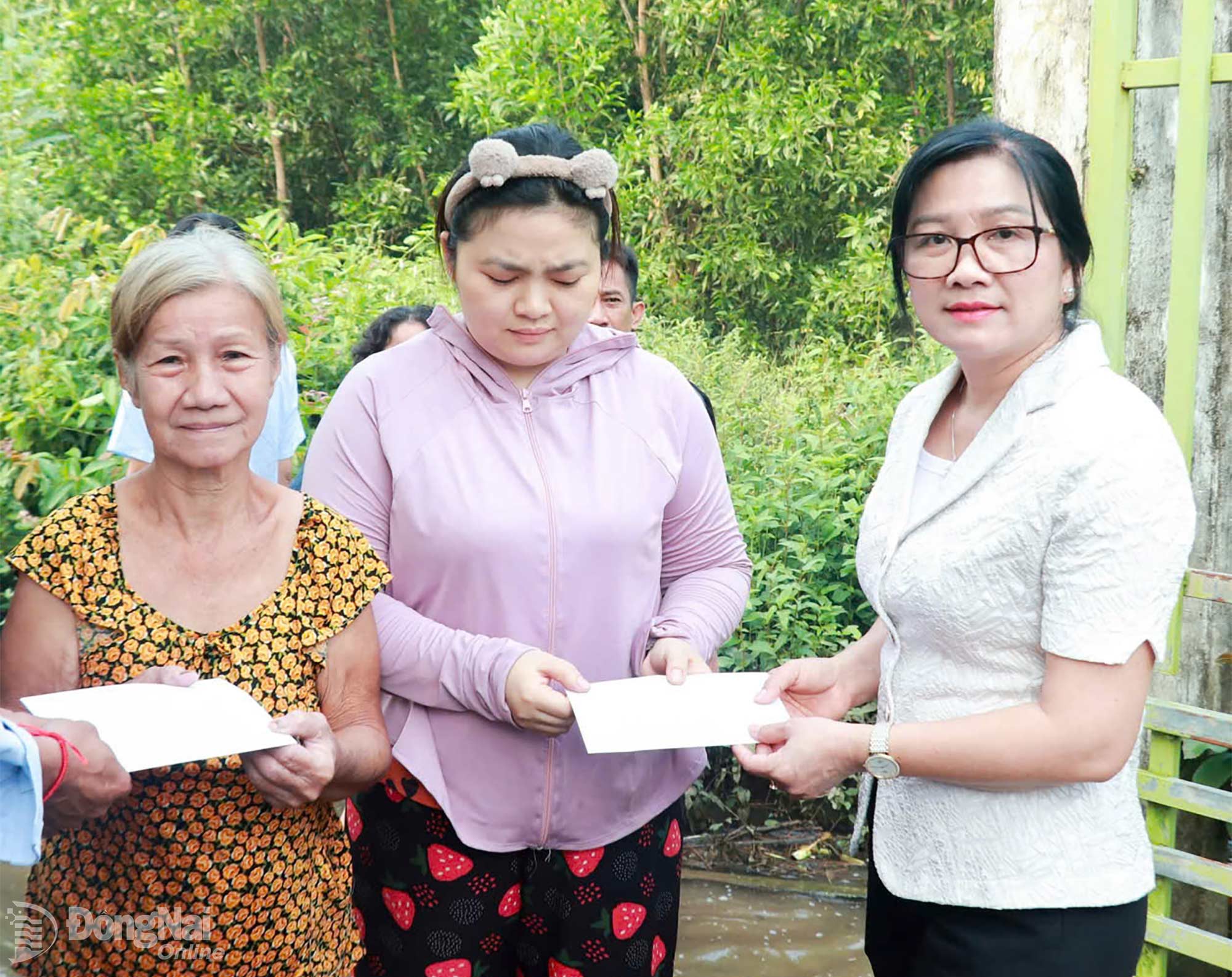 Bí thư Đảng ủy, Chủ tịch HĐND xã Tân An Lê Đỗ Kim Chi hỗ trợ người dân bị ảnh hưởng ngập úng do mưa. Ảnh: ĐVCC

