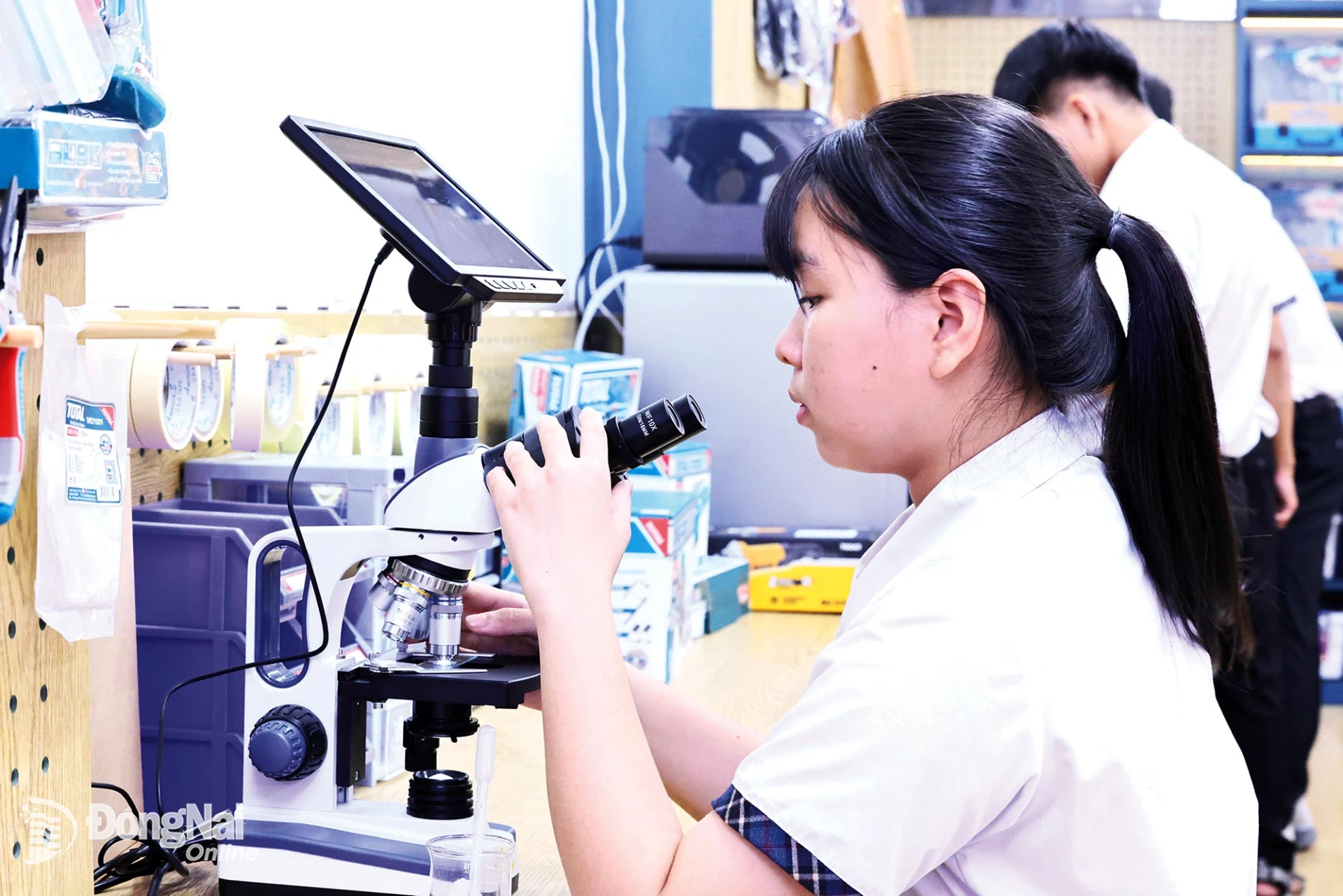 Students at Thong Nhat A High School in Trang Bom Ward practice with a computer-connected electron microscope.

