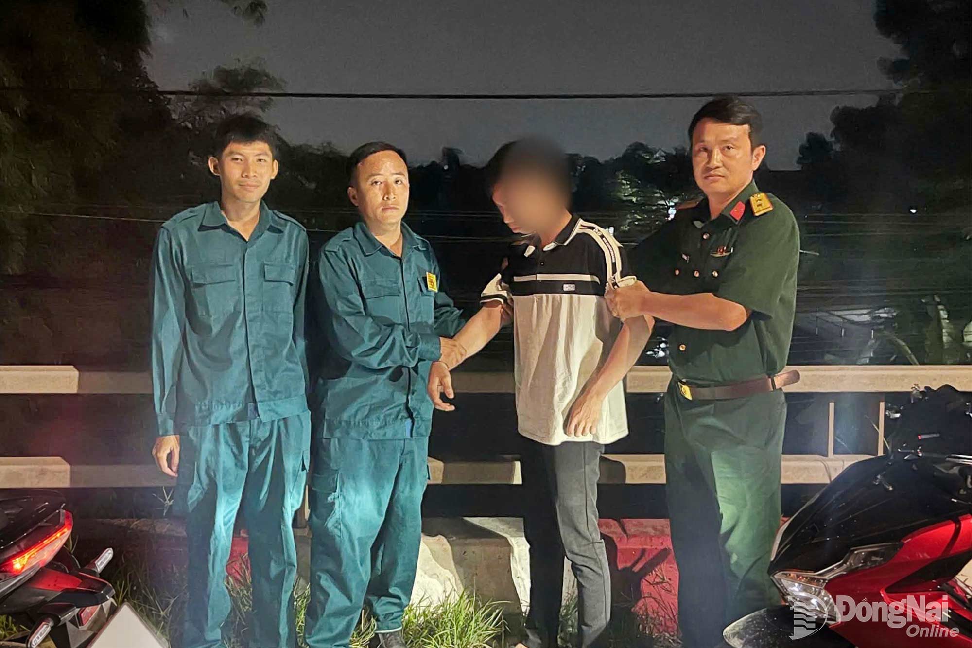 Lực lượng Ban Chỉ huy quân sự phường Phước Tân kịp thời động viên người đàn ông có ý định nhảy cầu sông Buông. Ảnh: ĐVCC