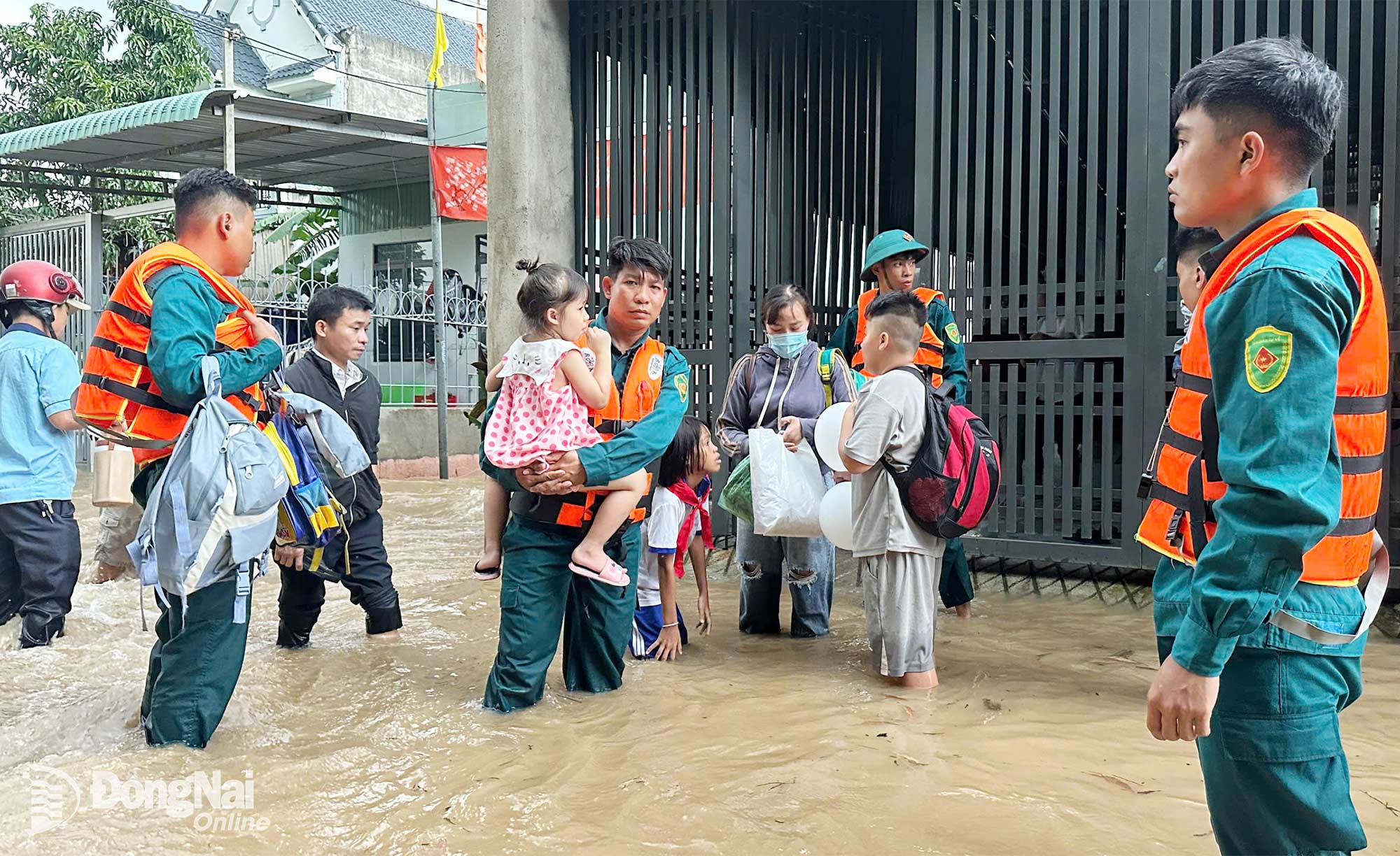 Lực lượng chức năng phường Phước Tân hỗ trợ đưa người dân qua vùng ngập. Ảnh: CTV