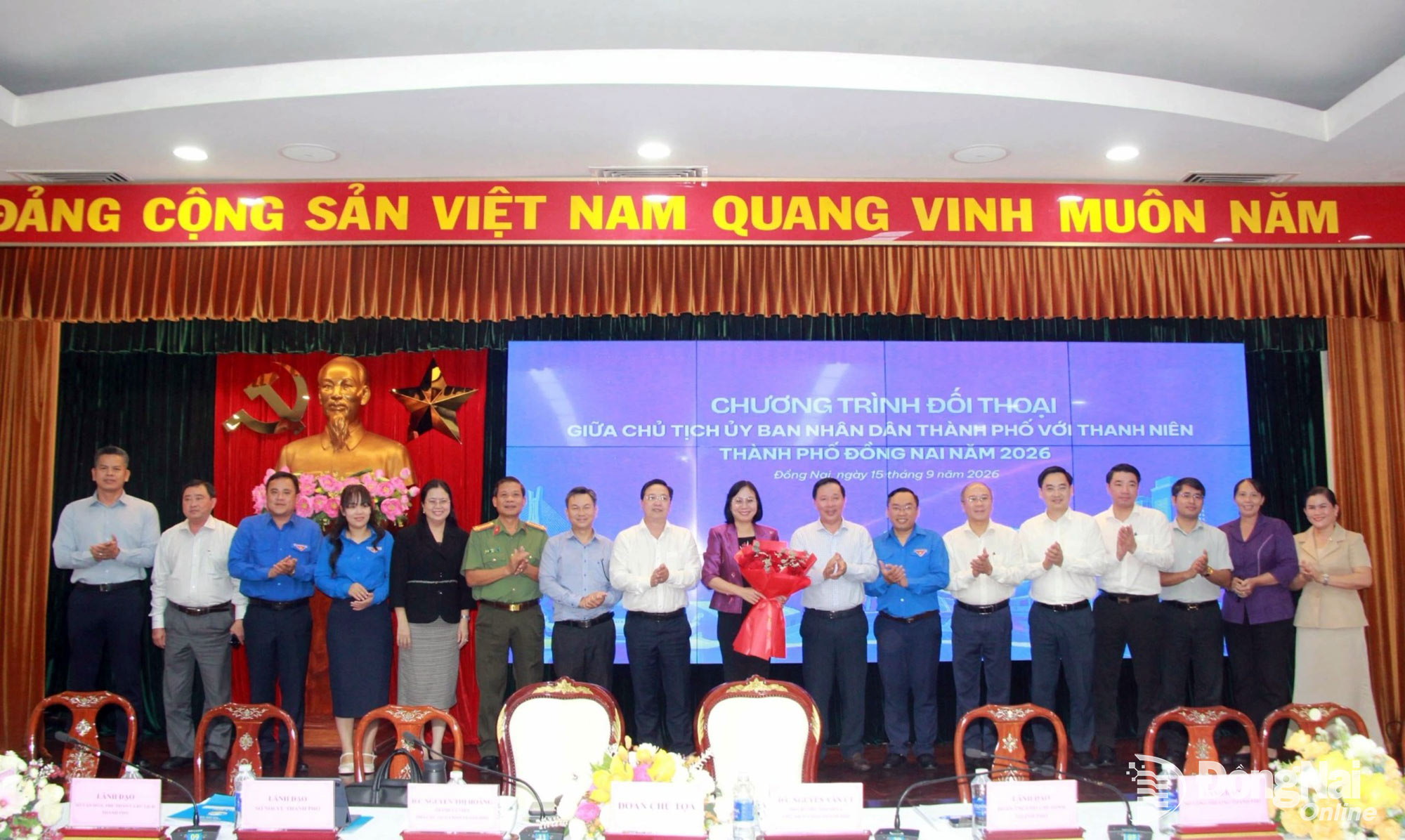 Standing members of the Dong Nai Youth Union present flowers to city leaders and representatives of departments, agencies and mass organizations and pose for a commemorative photo before the dialogue concludes. Photo: Nga Son