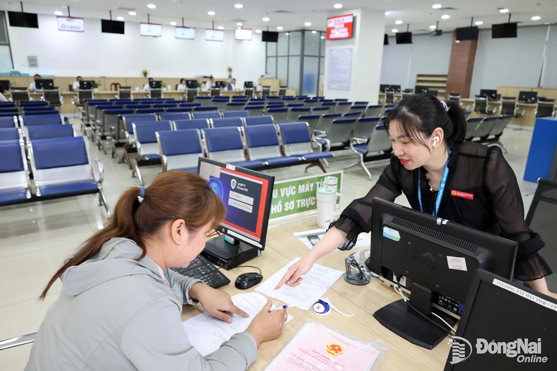 Viên chức Văn phòng Đăng ký đất đai thành phố hướng dẫn người dân rà soát giấy tờ, hoàn chỉnh tờ khai.

