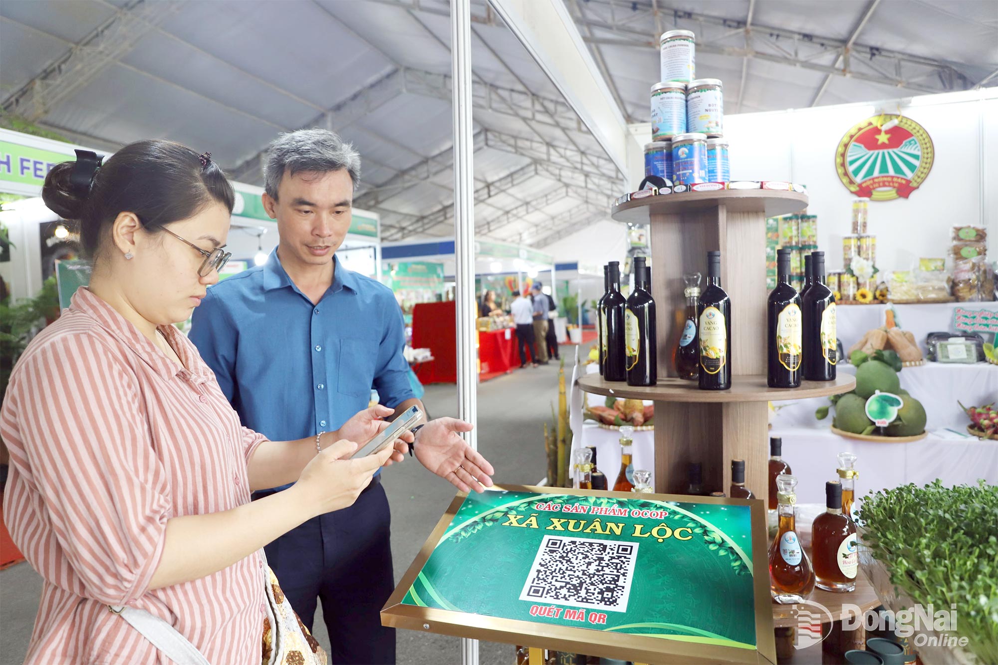 Người tiêu dùng sử dụng điện thoại thông minh để truy xuất nguồn gốc nông sản tại chương trình triển lãm thành tựu nông nghiệp Đồng Nai năm 2025.