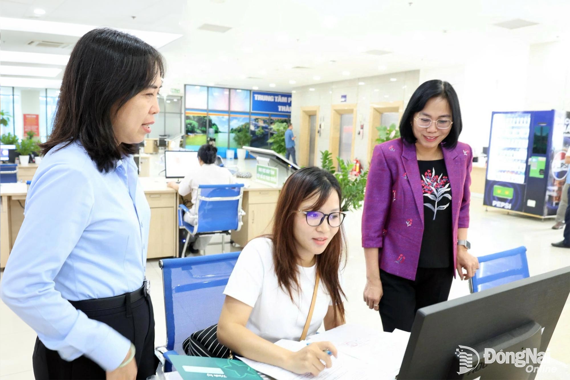 Member of the City Party Committee and Vice Chairwoman of the City People’s Committee Nguyen Thi Hoang and leaders of the Dong Nai Public Administrative Service Center speak with citizens coming to complete administrative procedures at the center. Photo: Ho Thao

