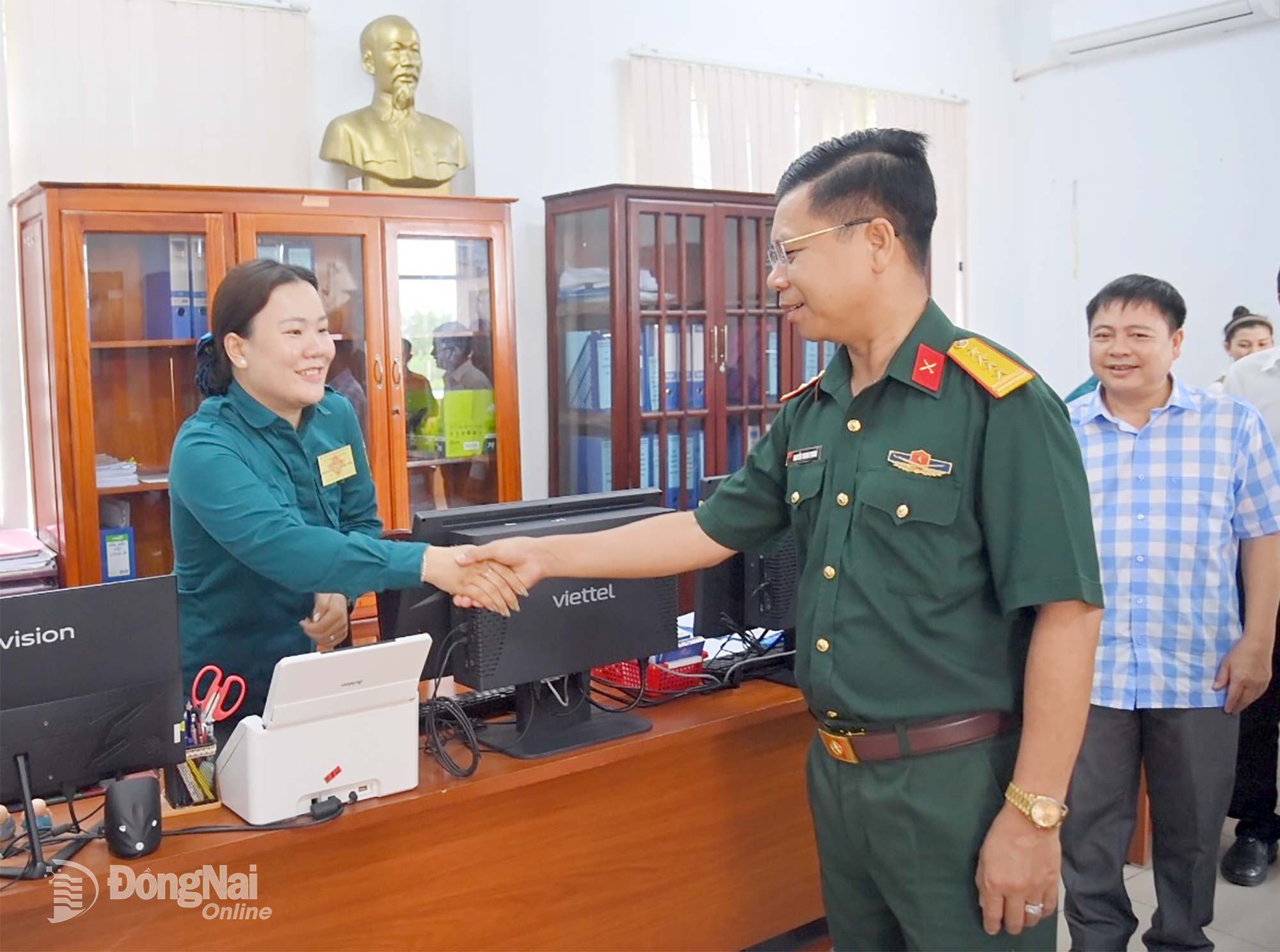 Đại tá Nguyễn Thanh Phong động viên nữ dân quân đang làm việc tại Ban Chỉ huy quân sự xã Xuân Hòa. Ảnh: Văn Chung