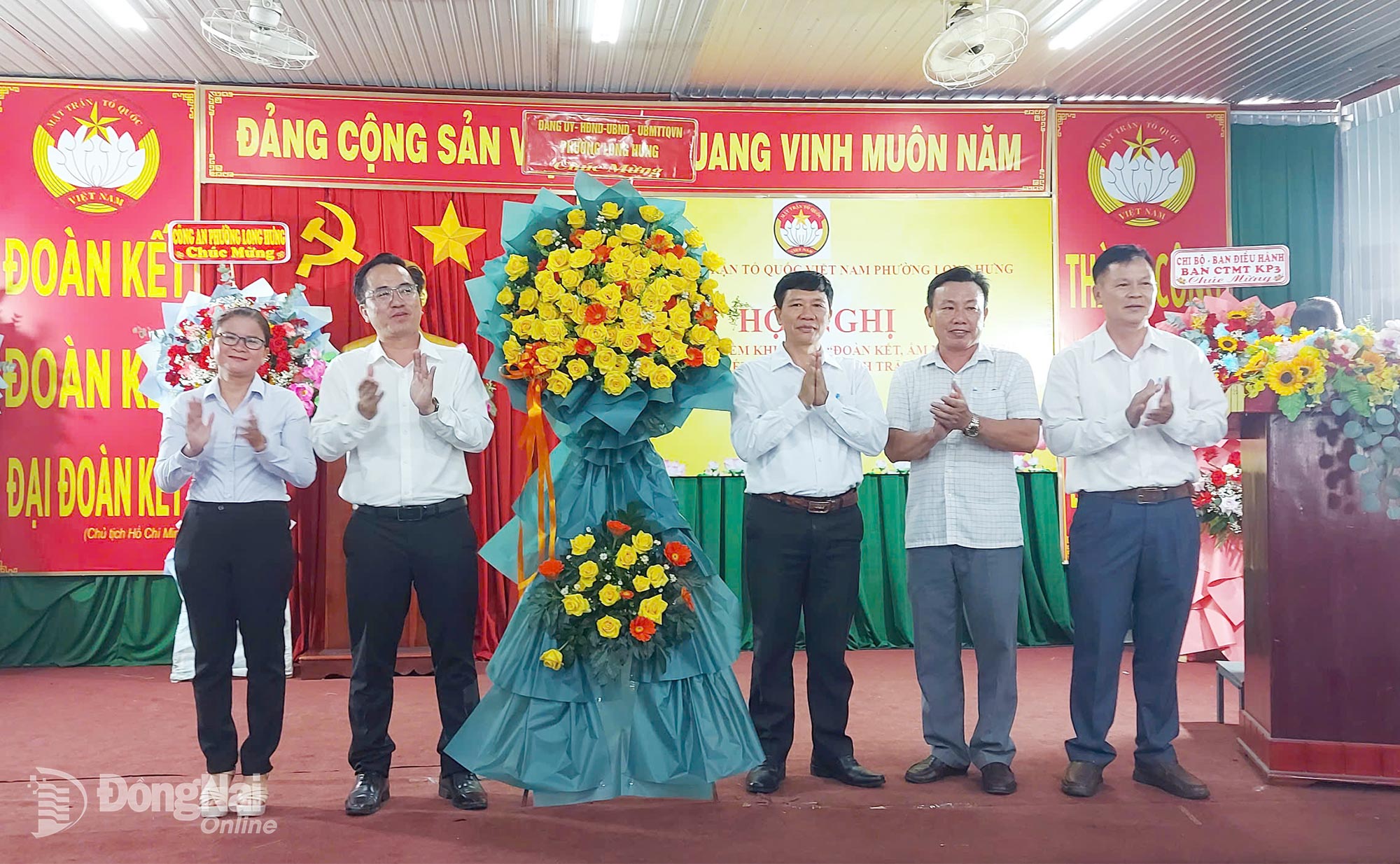 Lãnh đạo Đảng ủy phường Long Hưng tặng hoa chúc mừng Khu dân cư khu phố 3 được chọn làm điểm. Ảnh: Đỗ Hồng