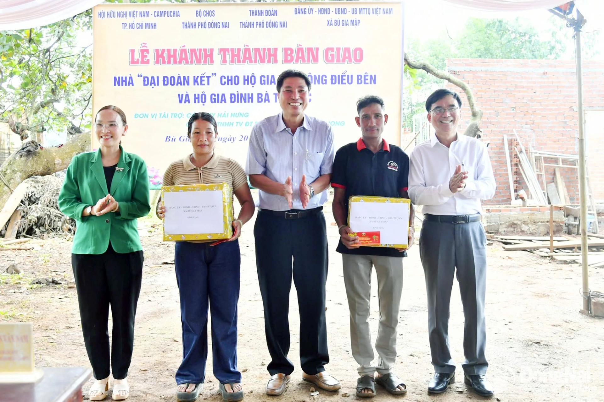 Leaders of Bu Gia Map Commune present gifts to the two households receiving the houses. Photo: Minh Tien

