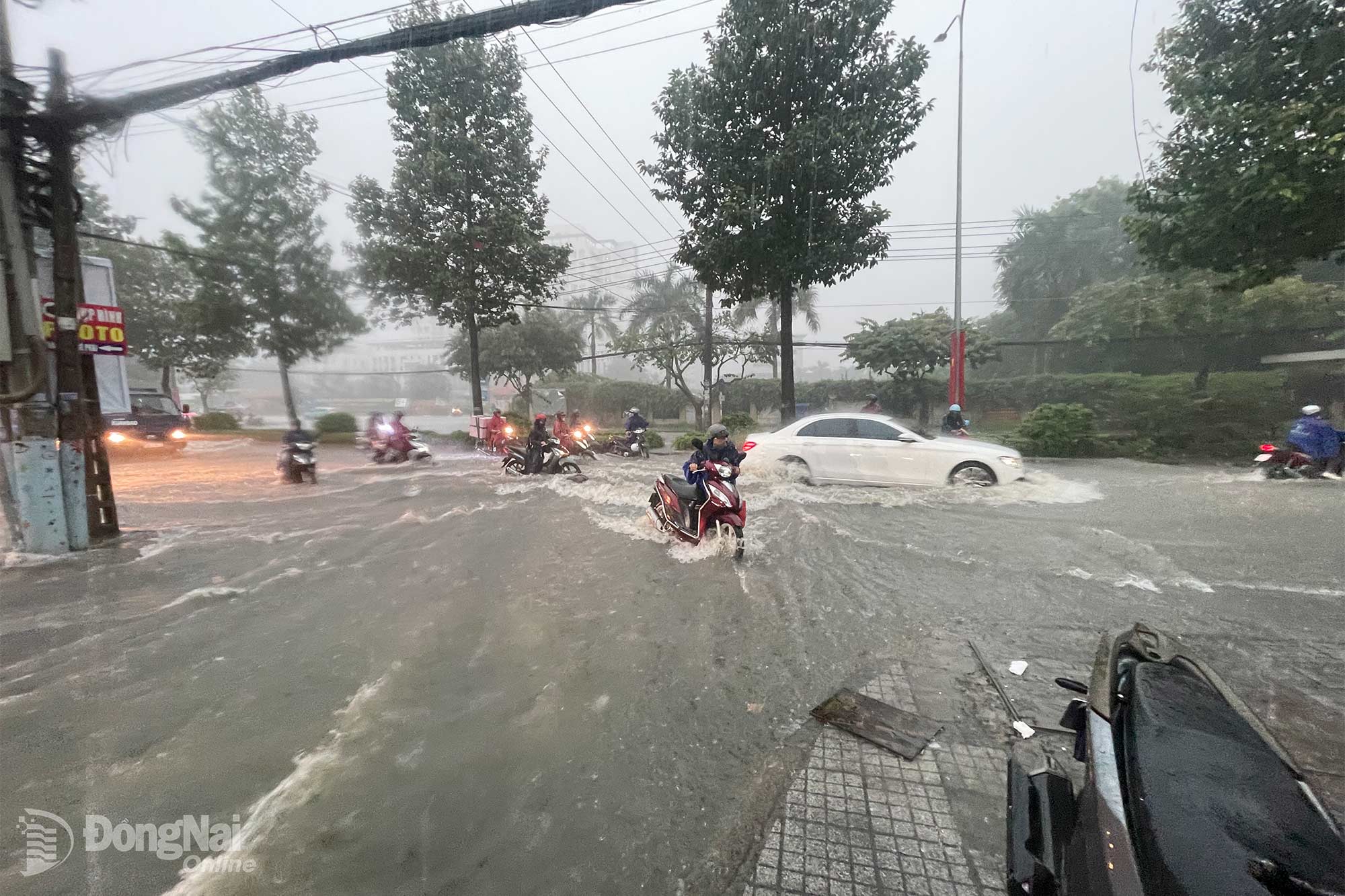 Tuyến đường Đồng Khởi ngập khiến người dân phải dắt xe vào lề chờ nước rút để di chuyển tiếp. Ảnh: Lê Duy