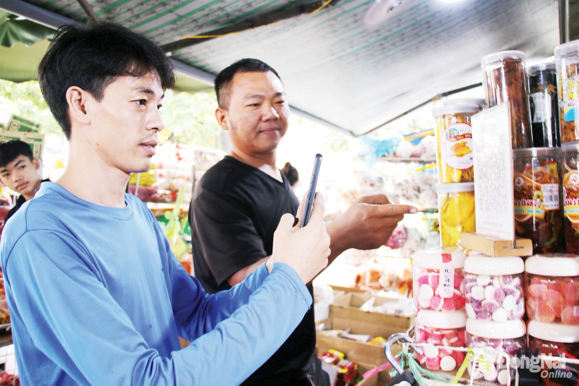 Khách hàng thanh toán không dùng tiền mặt khi mua sắm tại chợ Long Thành (phường Long Thành).
