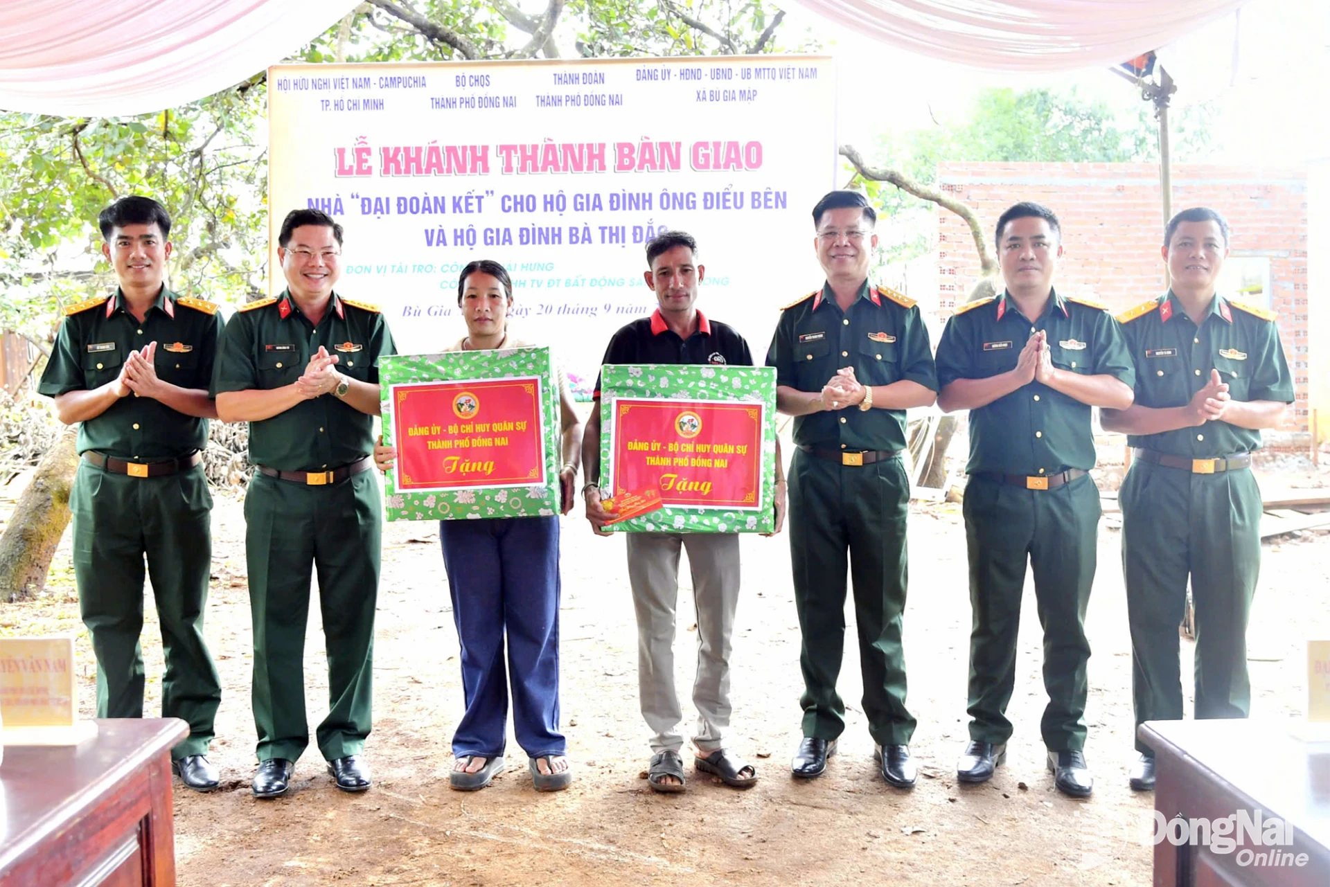 Thủ trưởng Bộ Chỉ huy Quân sự thành phố tặng quà cho 2 hộ trong lễ bàn giao nhà. Ảnh: Minh Tiến