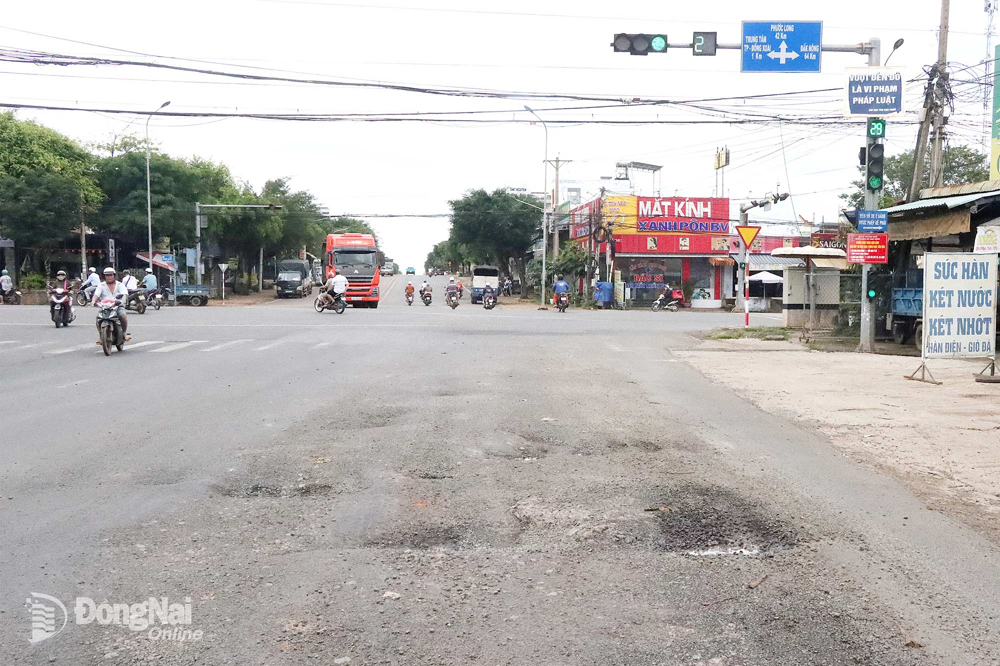 Vị trí gần ngã tư OSAKA giao nhau giữa đường Nguyễn Huệ và quốc lộ 14 dày đặc ổ gà, cần sớm được sửa chữa. Ảnh: Quang Minh