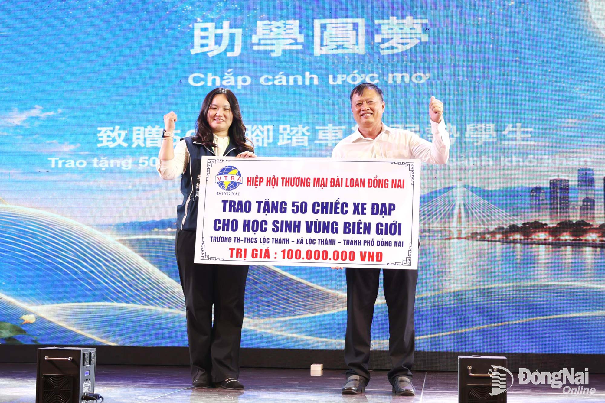 Đại diện Ủy ban MTTQ Việt Nam thành phố Đồng Nai nhận bảng tượng trưng 50 xe đạp cho học sinh hoàn cảnh khó khăn. Ảnh: Ngọc Liên