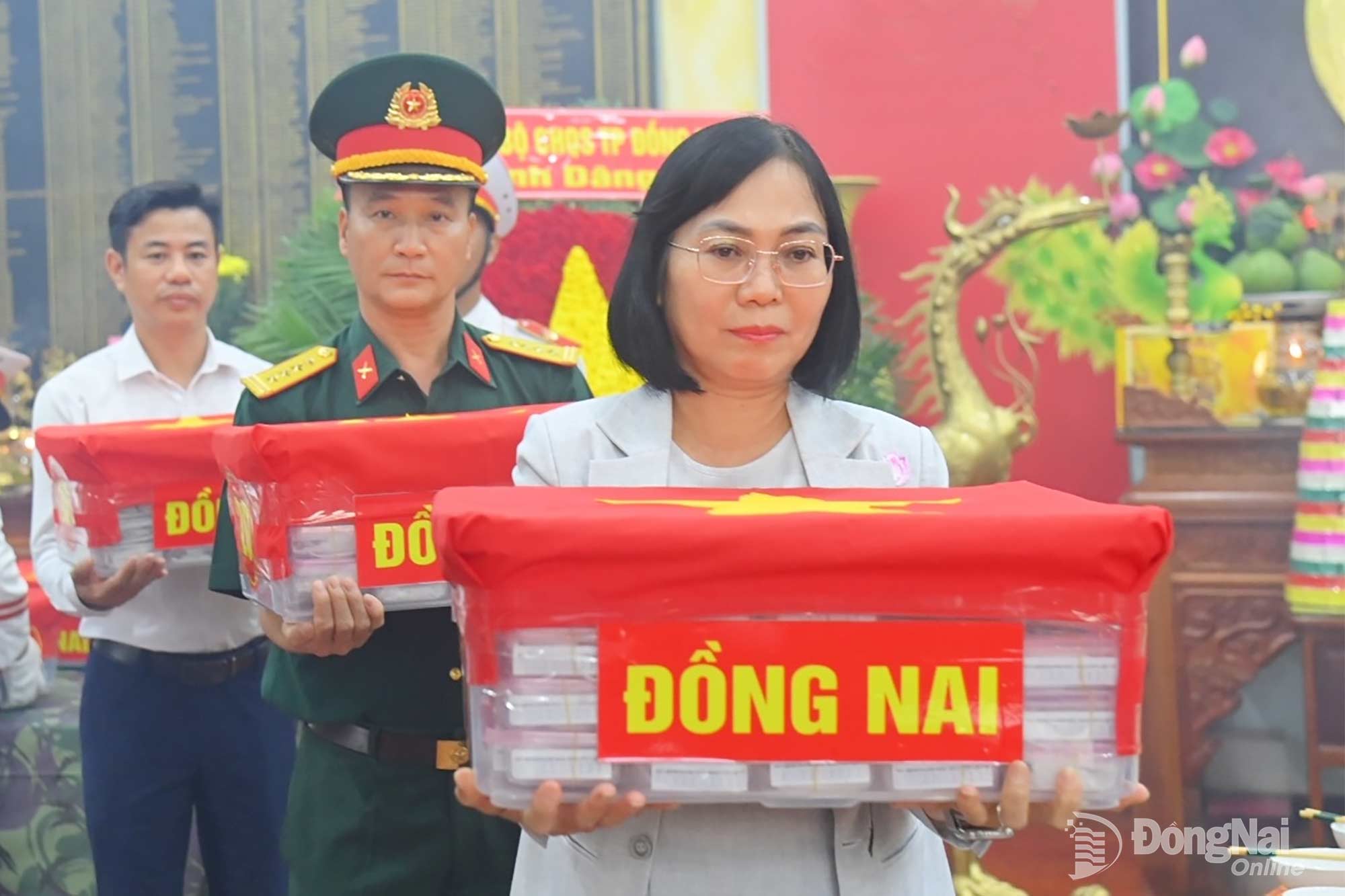 Thành ủy viên, Phó Chủ tịch UBND, Trưởng ban Chỉ đạo Tìm kiếm, quy tập và xác định danh tính hài cốt liệt sĩ thành phố Nguyễn Thị Hoàng và đại biểu trang trọng bàn giao các mẫu phẩm để giám định ADN. Ảnh: Văn Chung