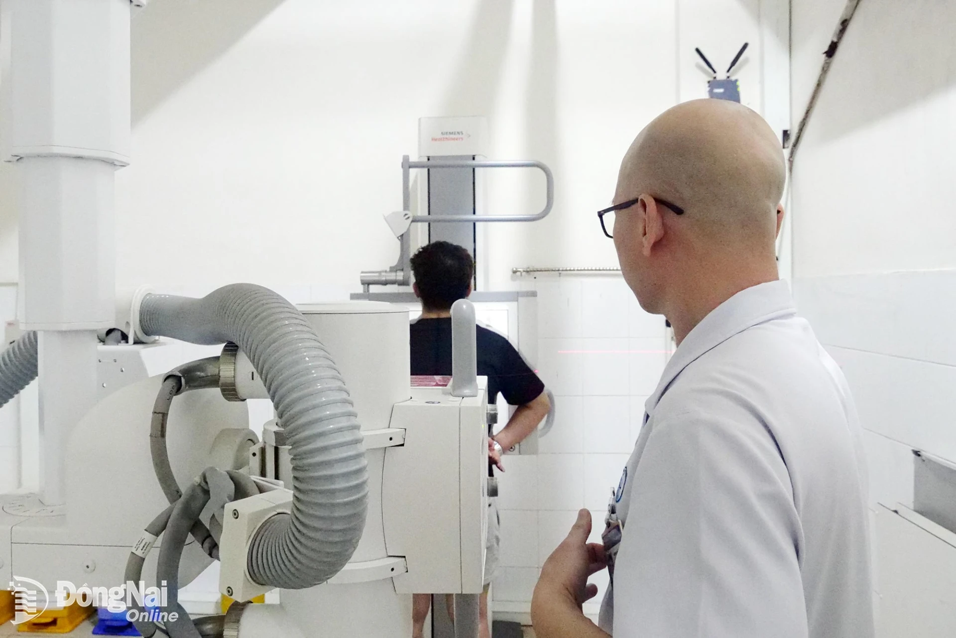 A staff member at Thong Nhat General Hospital performs an X-ray examination on a patient.