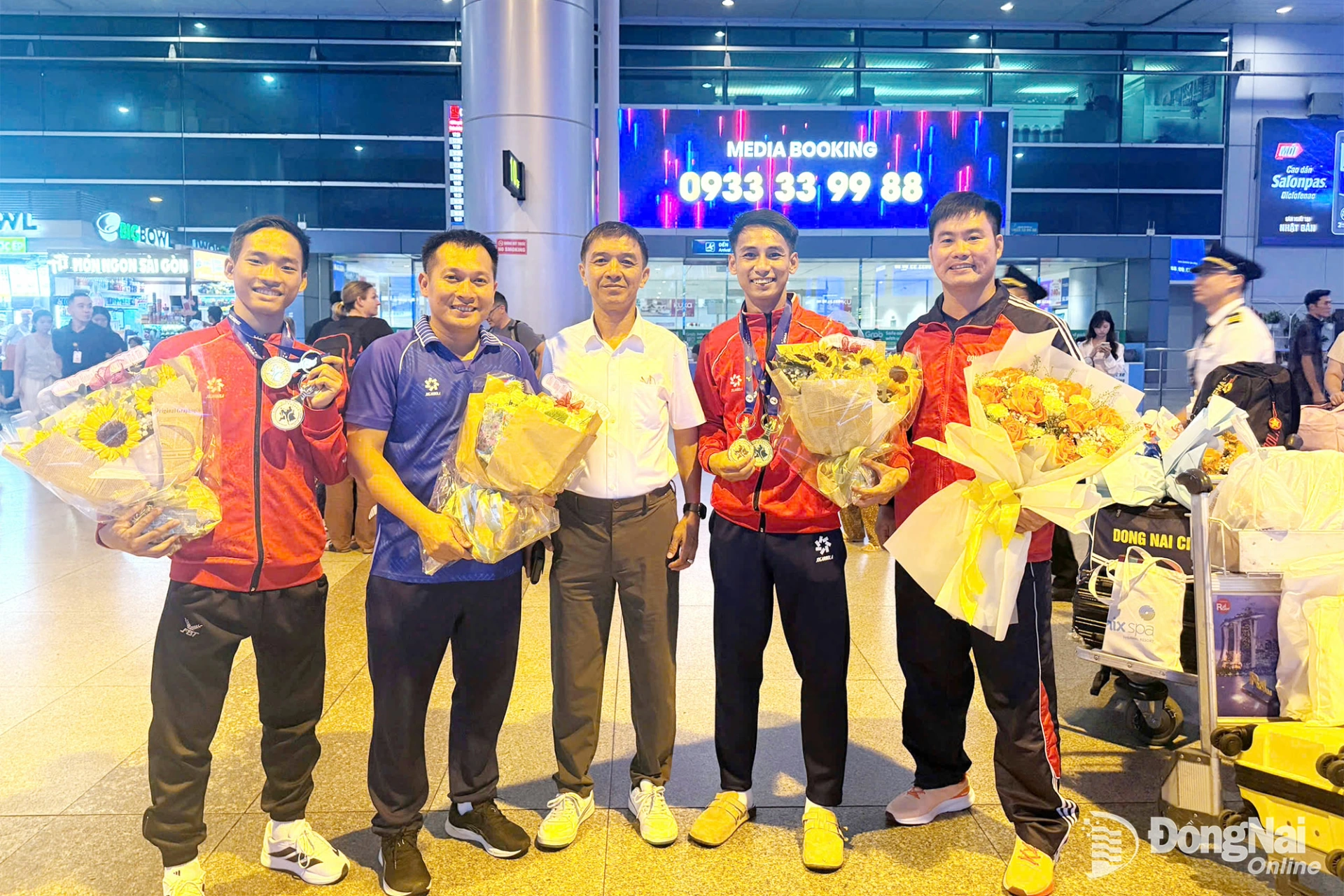 Ông Vũ Tiến Phát, Trưởng phòng Huấn luyện thể thao thành tích cao - Trung tâm Huấn luyện và Thi đấu thể thao thành phố Đồng Nai (giữa) chúc mừng thầy trò huấn luyện viên Huỳnh Ngọc Anh (thứ hai từ trái qua) tại Sân bay Tân Sơn Nhất. Ảnh: ĐVCC