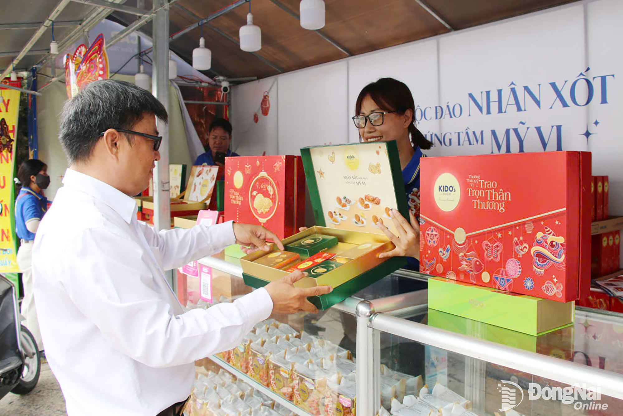 Người tiêu dùng tham khảo, chọn mua sản phẩm tại một sạp kinh doanh bánh trung trung thu ở khu vực gần nút giao Tân Phong, đoạn qua phường Tam Hiệp. Ảnh: Hải Quân