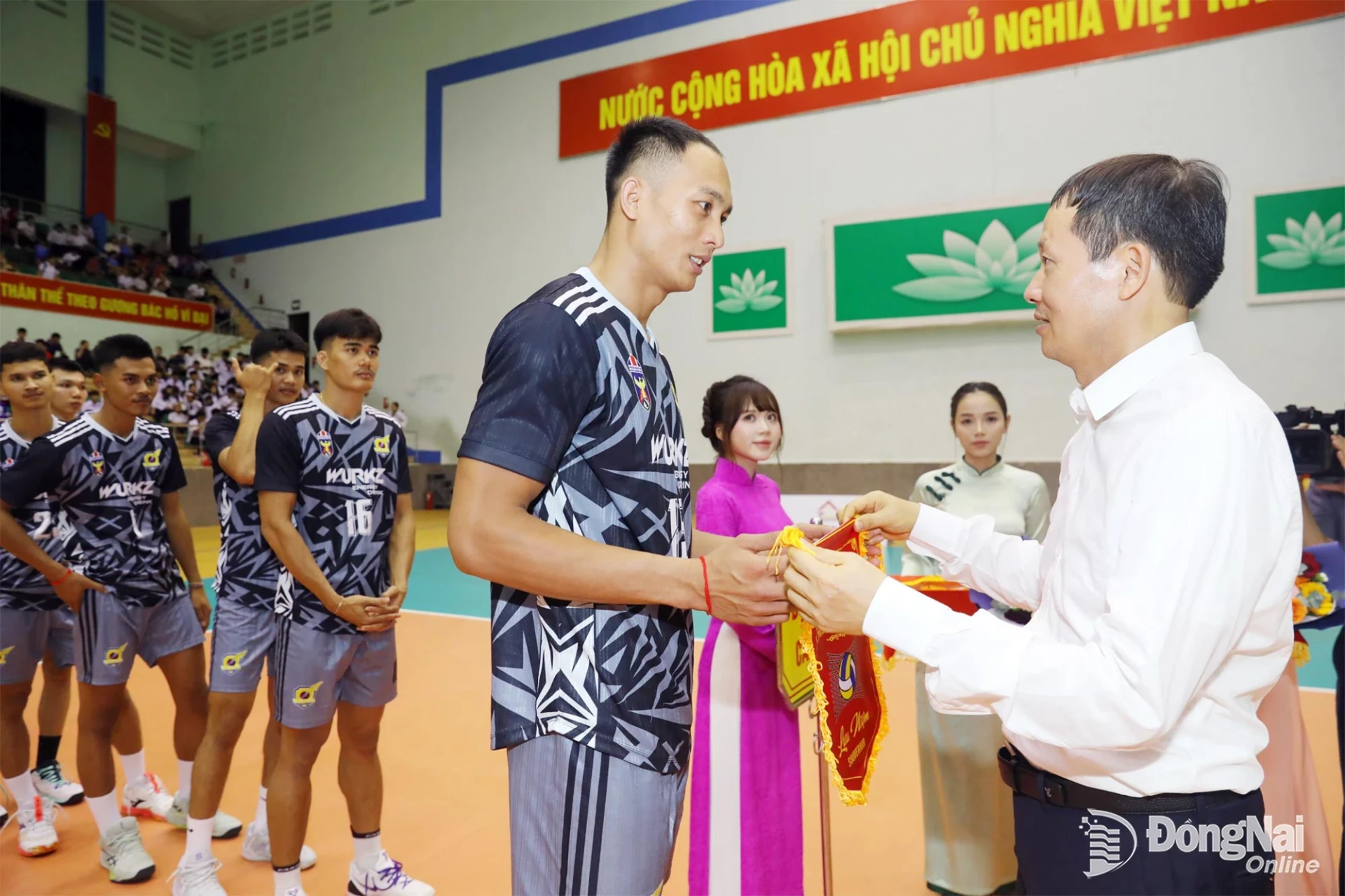 Vu Hong Van, Member of the Party Central Committee, Secretary of the Dong Nai City Party Committee, Head of the Dong Nai Delegation of NA Deputies, presents a commemorative flag to a representative of Cambodia’s Visakha team. Photo: Huy Anh

