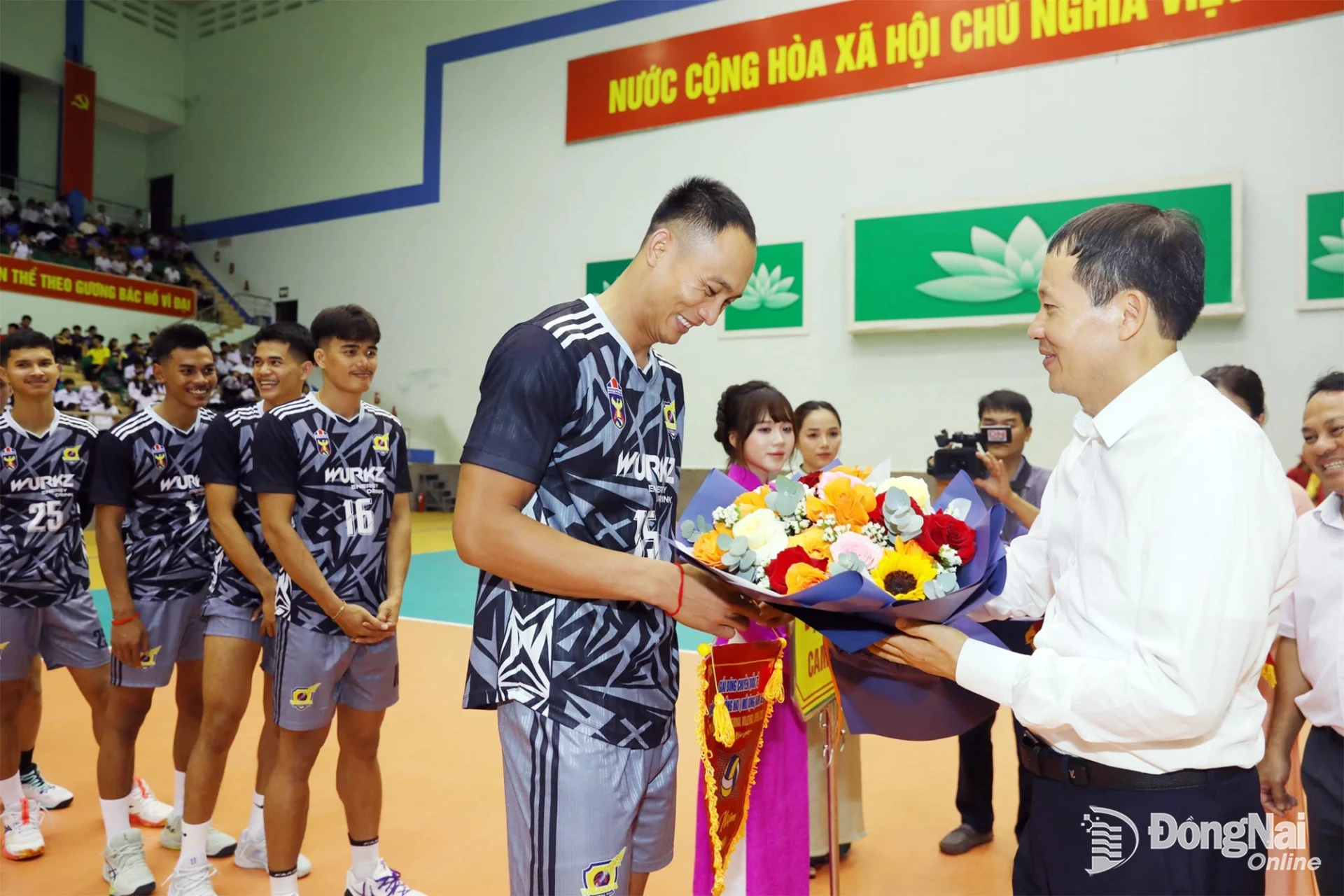 Vu Hong Van, Member of the Party Central Committee, Secretary of the Dong Nai City Party Committee, Head of the Dong Nai Delegation of NA Deputies, presents a commemorative flag to a representative of Cambodia’s Visakha team. Photo: Huy Anh

