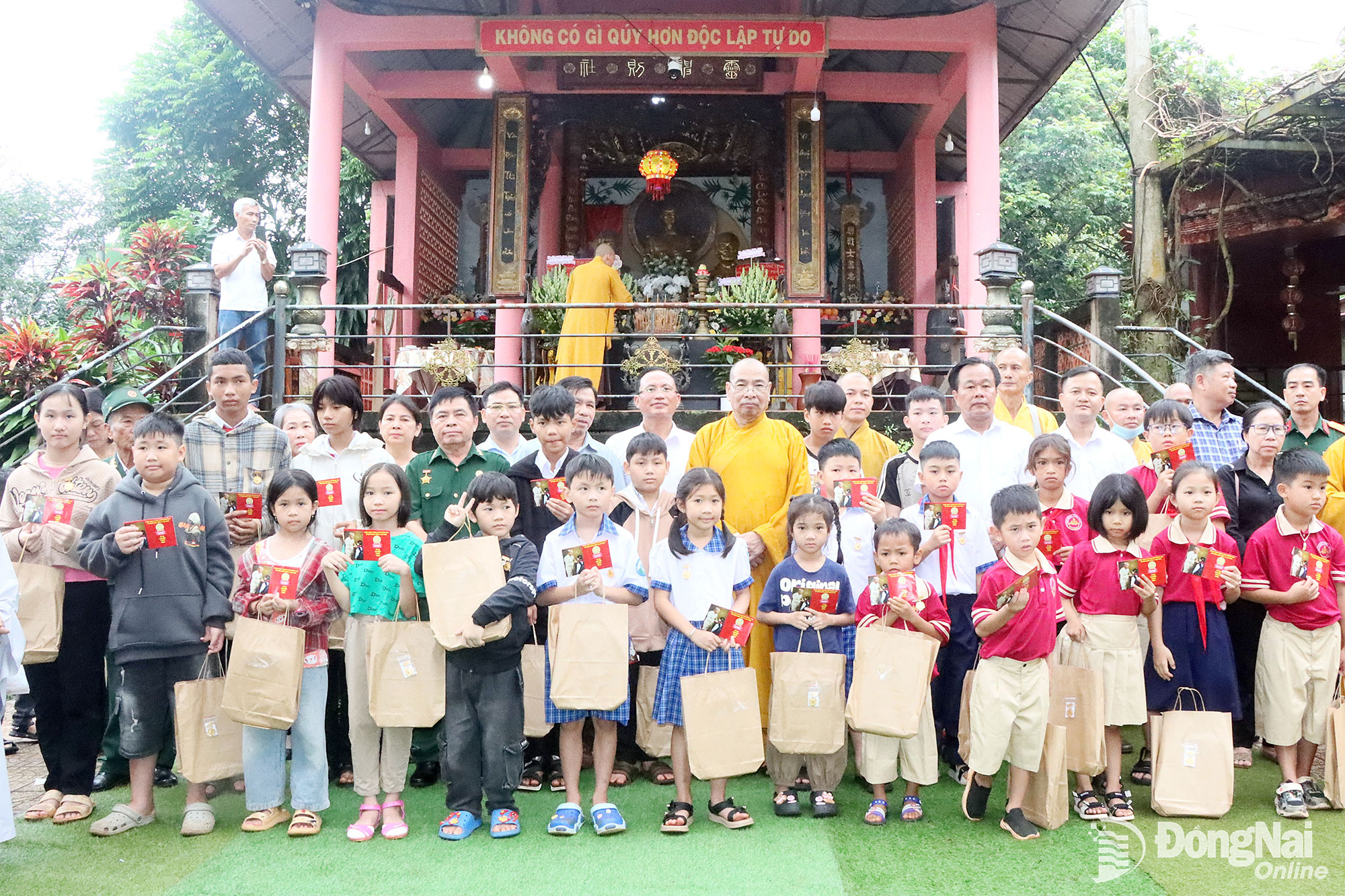 Thượng tọa Thích Đồng Tấn, Trụ trì chùa Đức Bổn A Lan Nhã, xã Nghĩa Trung cùng lãnh đạo các xã lân cận tặng quà cho học sinh tại chùa. Ảnh: Quang Minh