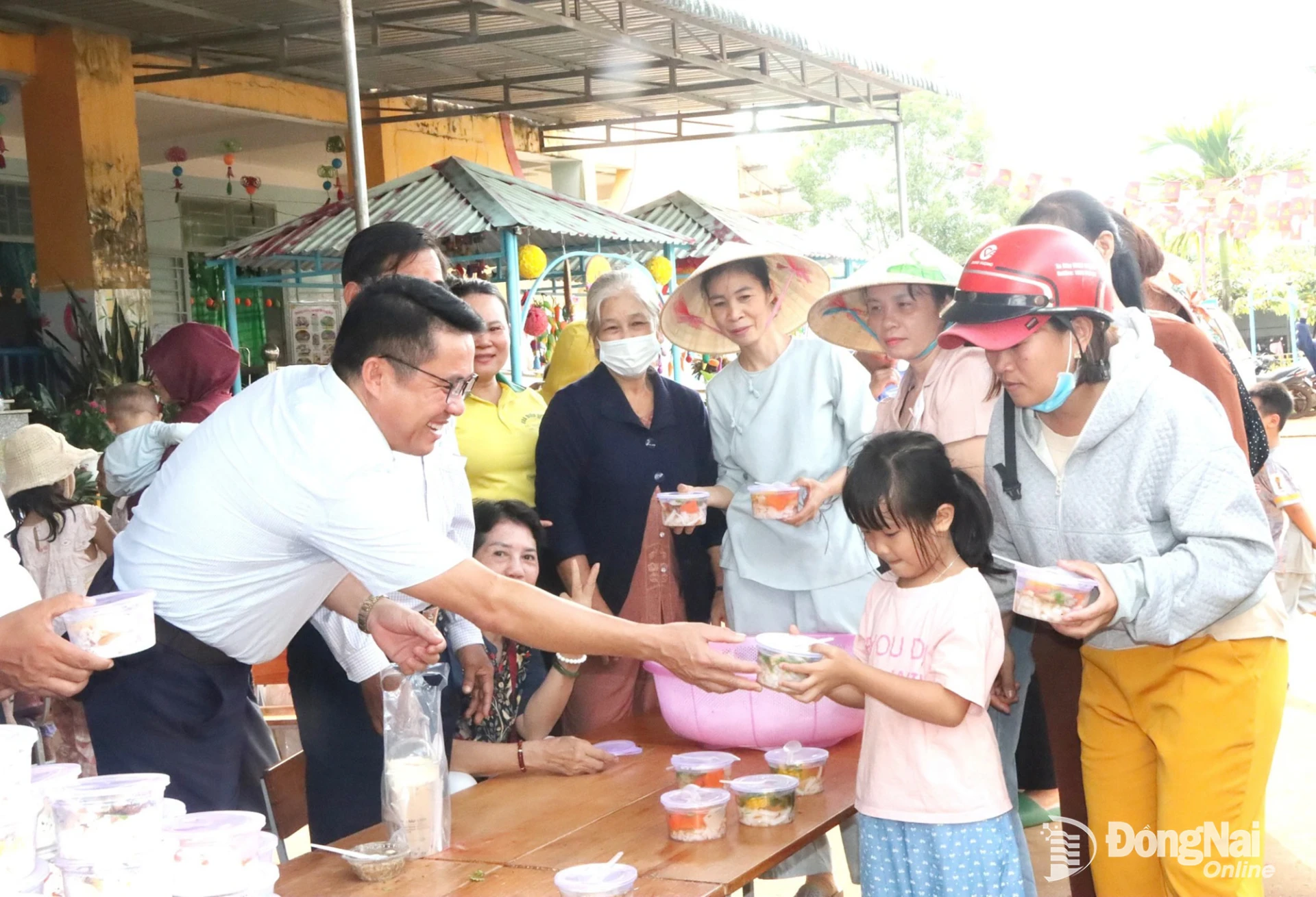 Lãnh đạo xã Đak Nhau và các phật tử tặng suất ăn chay miễn phí cho trẻ em và người dân trên địa bàn xã. Ảnh: Quang Minh
