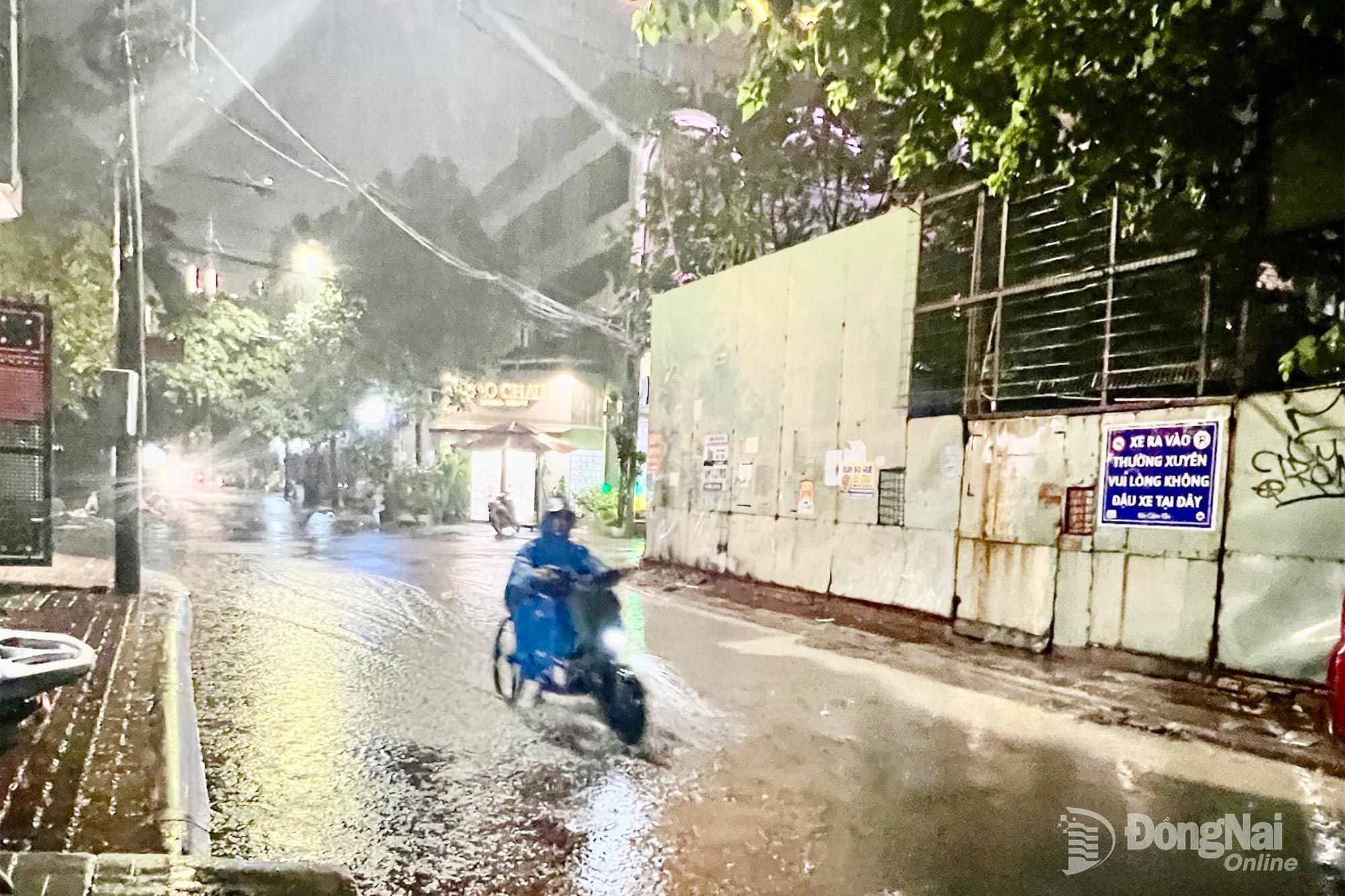 Người dân di chuyển trong cơn mưa lớn tại khu dân cư trên đường Võ Thị Sáu (phường Trấn Biên). Ảnh: Kim Liễu