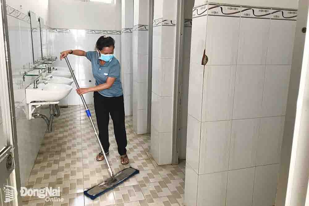 Lao công lau dọn nhà vệ sinh ở một trường học trên địa bàn TP.Biên Hòa