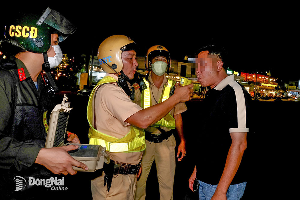 Lực lượng cảnh sát giao thông kiểm tra nồng độ cồn người đi xe máy tại H.Nhơn Trạch. Ảnh: Đ.Tùng