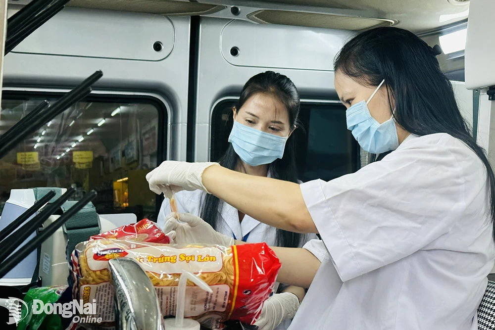 Nhân viên y tế thực hiện kiểm nghiệm các mẫu thực phẩm được bày bán tại một cơ sở kinh doanh thực phẩm trong tỉnh