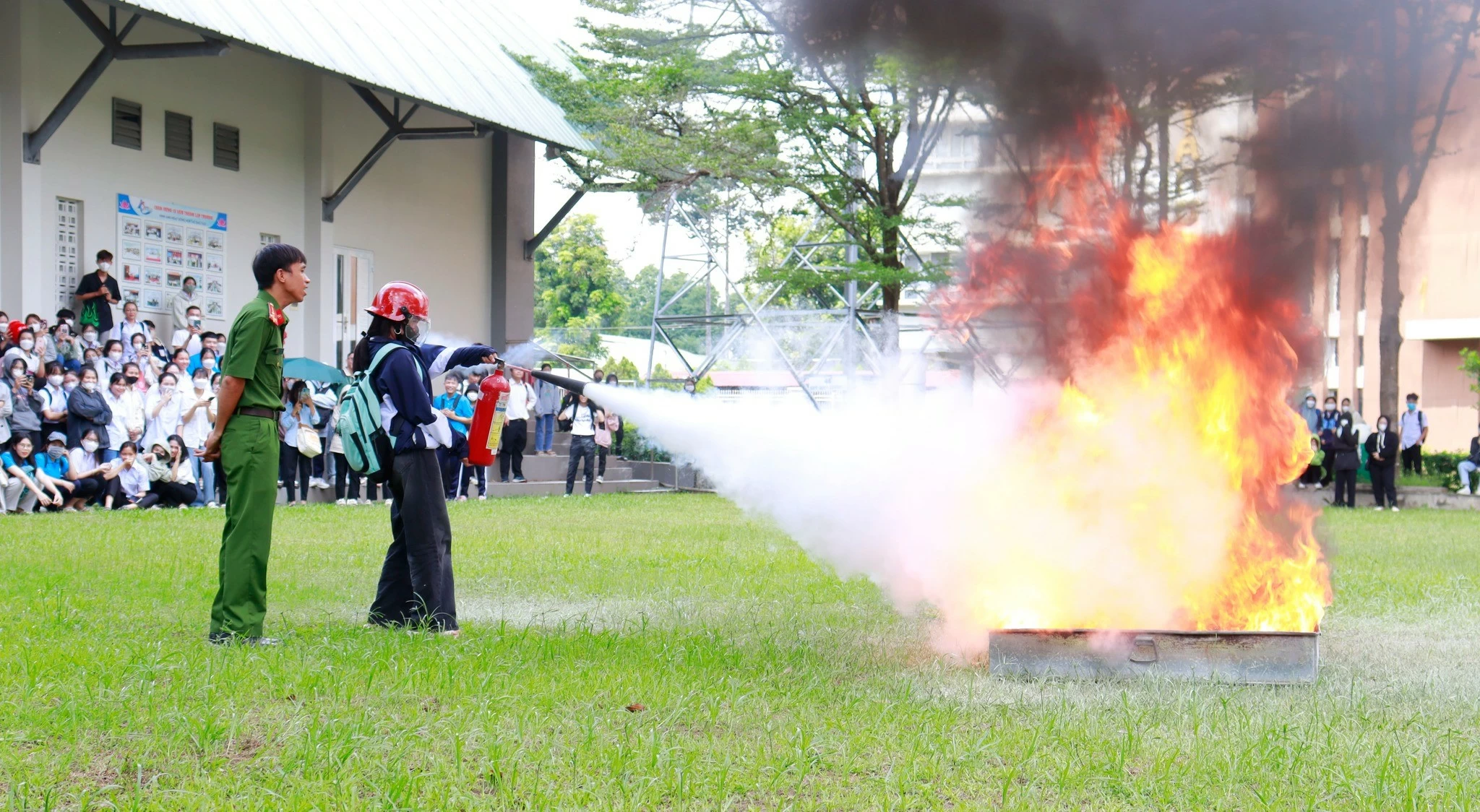 Sinh viên được hướng dẫn thực hành dập tắt đám cháy bằng bình cứu hỏa (ảnh: CTV)