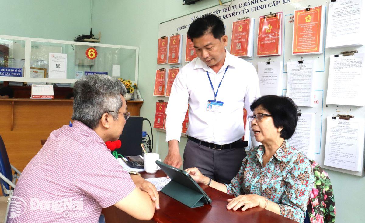 Lãnh đạo phường Trung Dũng hỗ trợ cán bộ thực hiện thẻ bảo hiểm y tế cho người dân. Ảnh: Nguyệt Hà