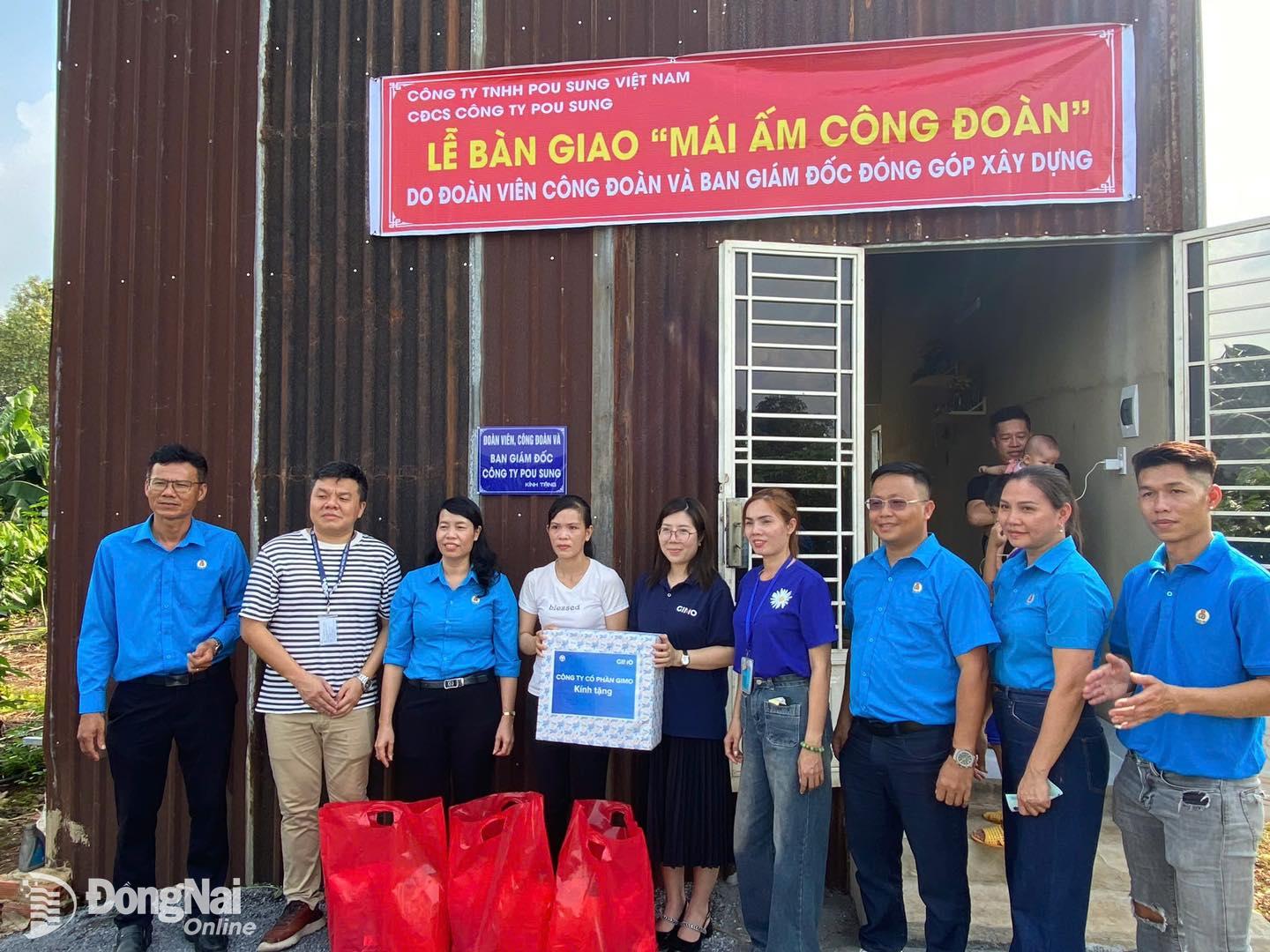 Đại diện Công đoàn công ty tặng quà cho đoàn viên Trần Thị Trang tại lễ bàn giao nhà. Ảnh: N.Hòa