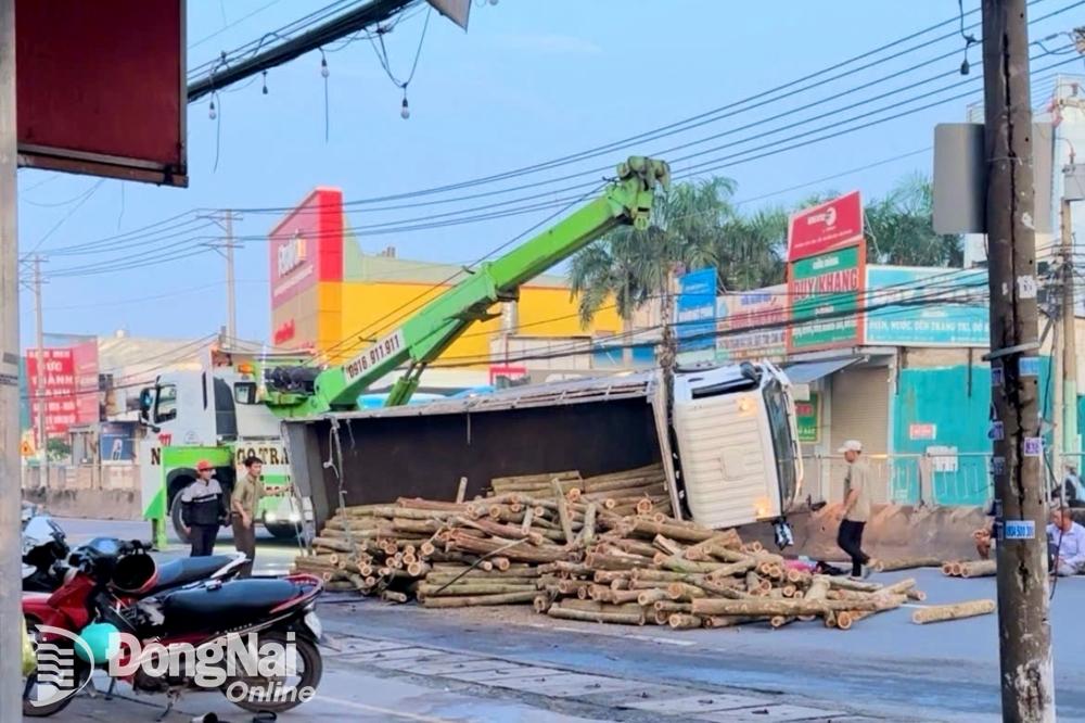 Xe tải lật ngang làm nhiều thanh gỗ đổ tràn ra quốc lộ 1 (thành phố Biên Hòa). Ảnh: Lê Duy