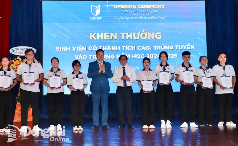 Phó chủ tịch UBND tỉnh Nguyễn Sơn Hùng và Hiệu trưởng Trường cao đẳng Công nghệ và quản trị Sonadezi Nguyễn Tiến Mạnh khen thưởng sinh viên đạt thành tích cao trong học tập. Ảnh: H.YẾN