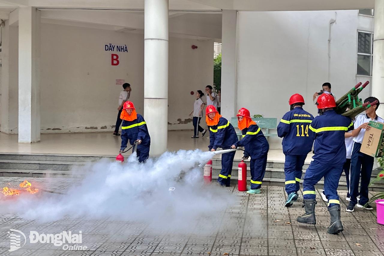 Cán bộ, nhân viên, học sinh Trường THPT chuyên Lương Thế Vinh tự sử dụng phương tiện chữa cháy tại chỗ để dập lửa. Ảnh: Đăng Tùng