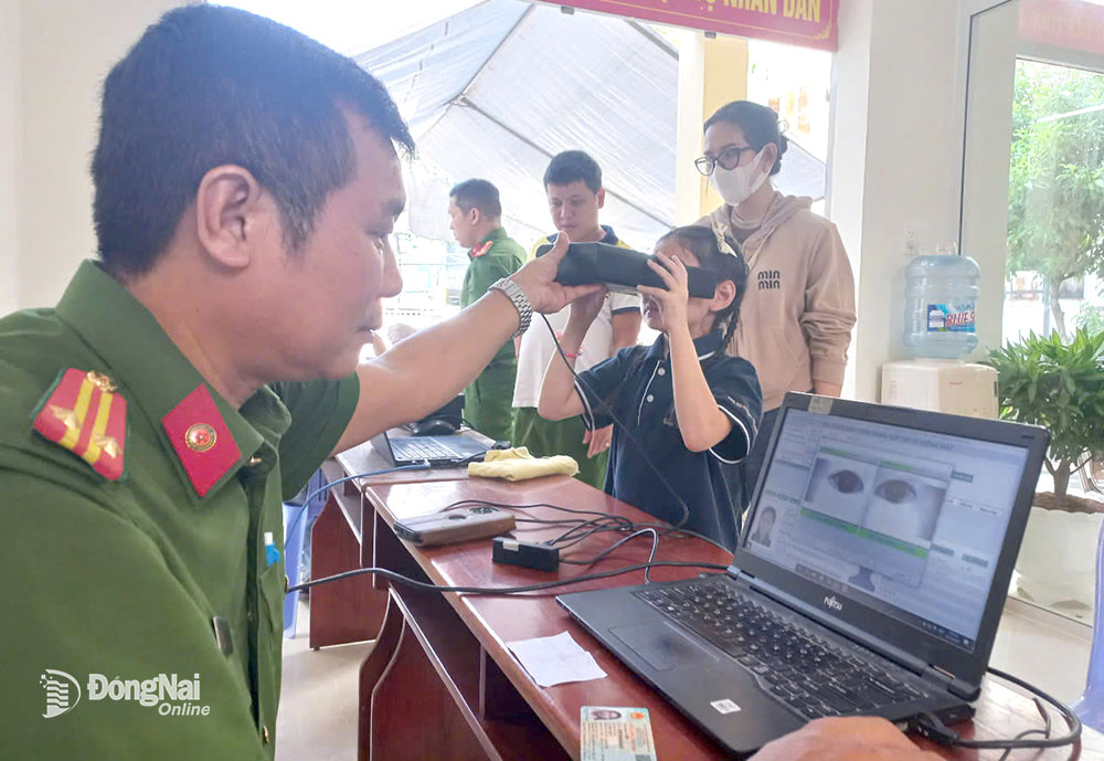 Cán bộ Công an phường Tam Hiệp (thành phố Biên Hòa) thu nhận dữ liệu cấp thẻ căn cước cho trẻ em. Ảnh: T.Danh