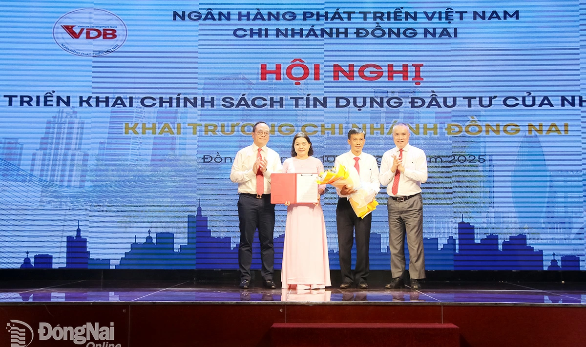 Lãnh đạo Ngân hàng Nhà nước chi nhánh khu vực 2 và lãnh đạo Ngân hàng Phát triển Việt Nam trao quyết định thành lập và tặng hoa chúc mừng Ngân hàng Phát triển Việt Nam chi nhánh Đồng Nai. Ảnh: Hải Quân