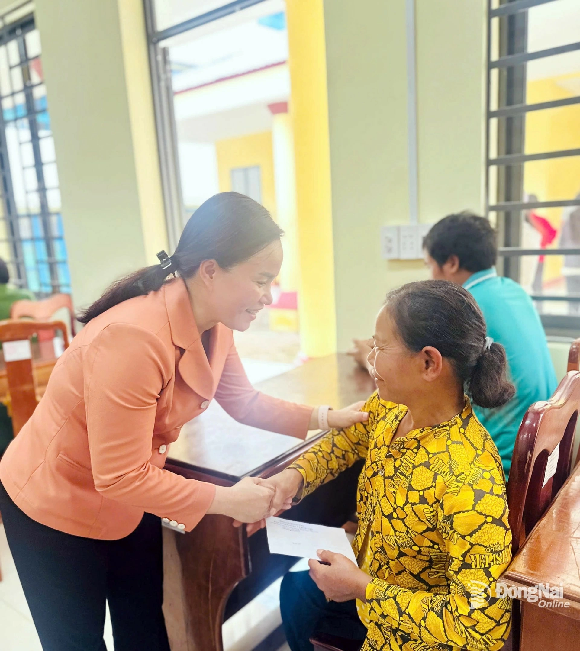 Member of the Provincial Party Committee and Deputy Head of the Dong Nai Provincial Party Committee’s Propaganda and Mass Mobilization Commission, Nguyen Thi Hong Trang, presents gifts to residents of Tho Son commune. Photo: Dao Nga