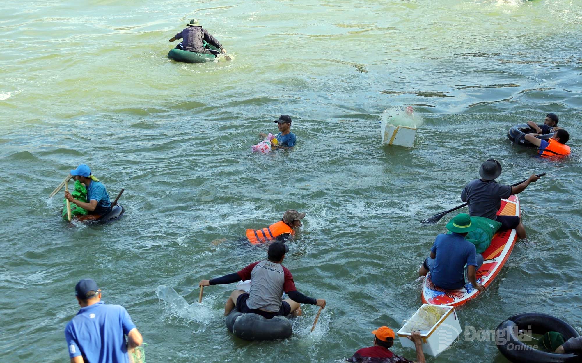 With the dam no longer releasing water, residents paddle boats and float on inner tubes to catch fish. Photo: Thuy Tien