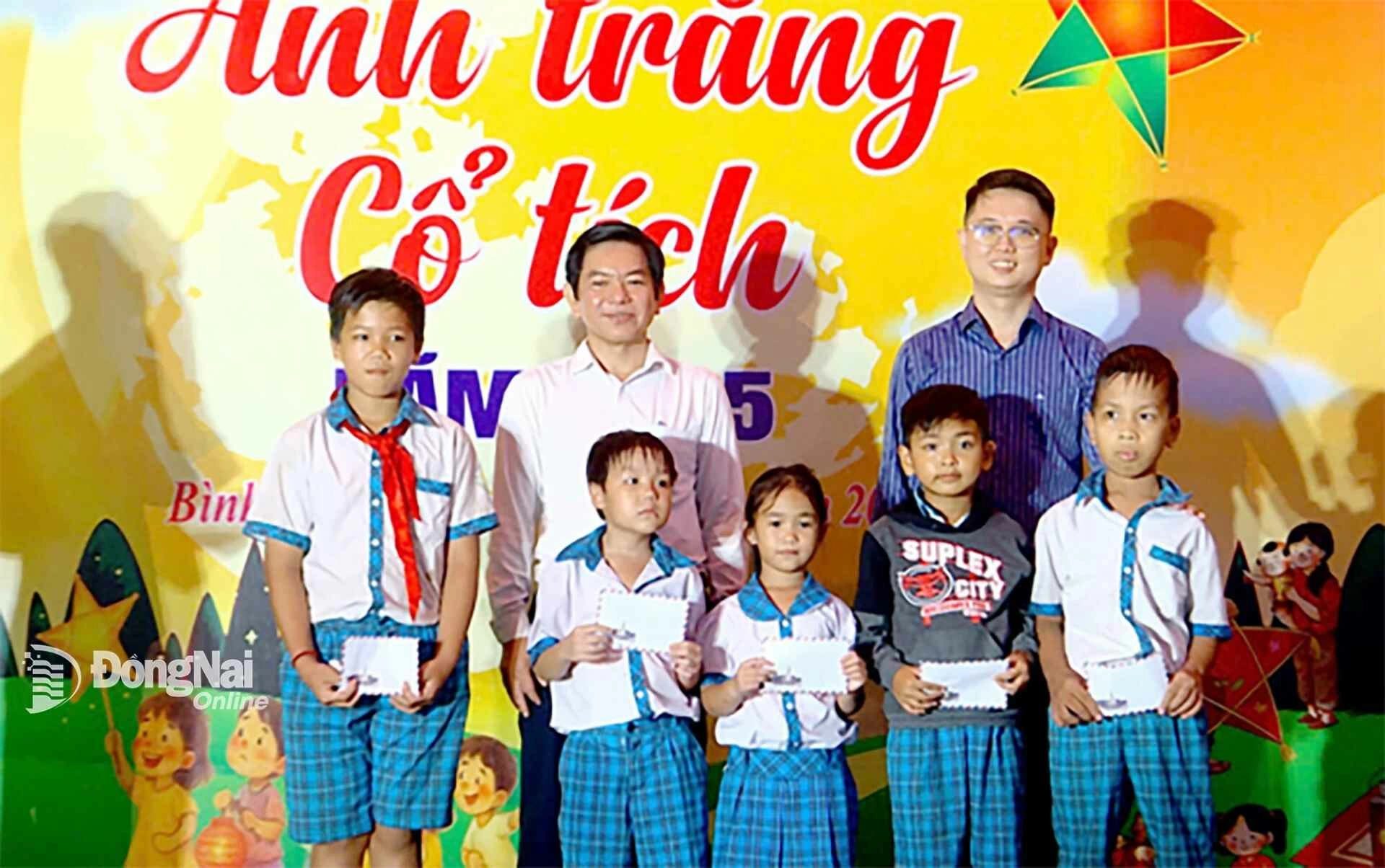 Representatives of the Youth Union of Dong Nai Newspaper and Radio, Television present scholarships to students who overcame difficulties to study well in Binh Minh commune. Photo: Hoang Hai