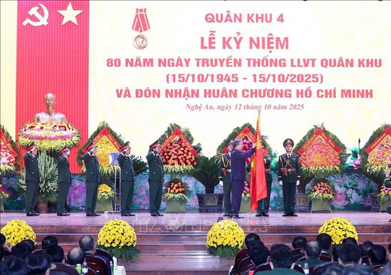 Tổng Bí thư Tô Lâm gắn Huân chương Hồ Chí Minh lên lá cờ truyền thống của Quân khu 4 - Ảnh: TXVN

